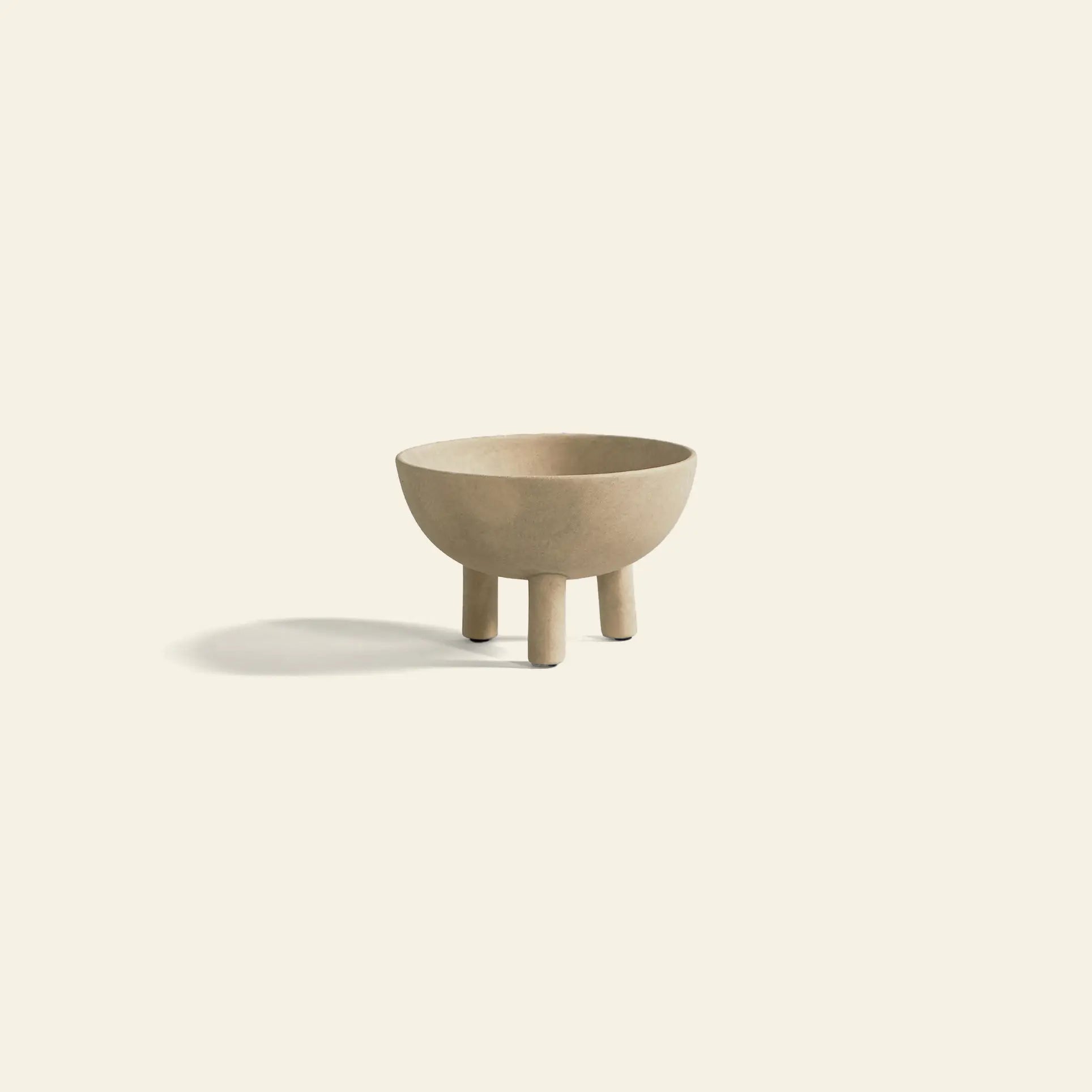 The 101 Copenhagen Duck Bowl, Big by 101 Copenhagen is a beige ceramic bowl with three cylindrical legs and Scandinavian-inspired design, shown on a light background with a soft shadow to the left.