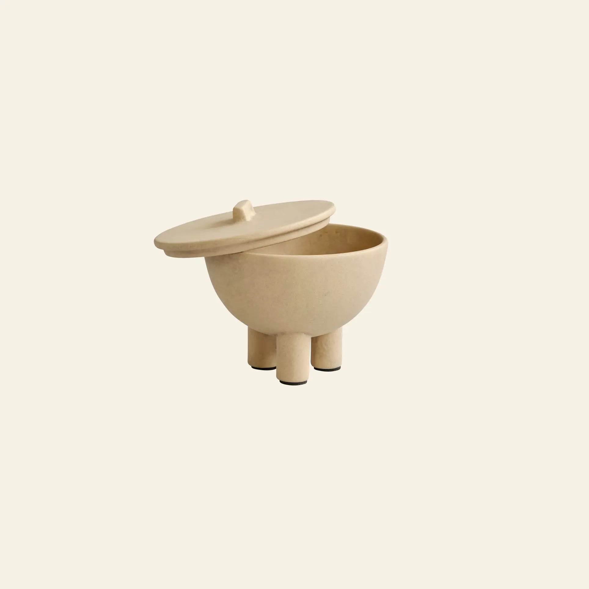 The 101 Copenhagen Duck Jar, Medio by 101 Copenhagen features a hand-glazed beige round design with three cylindrical legs and a matching lid—perfect decorative storage for any interior.