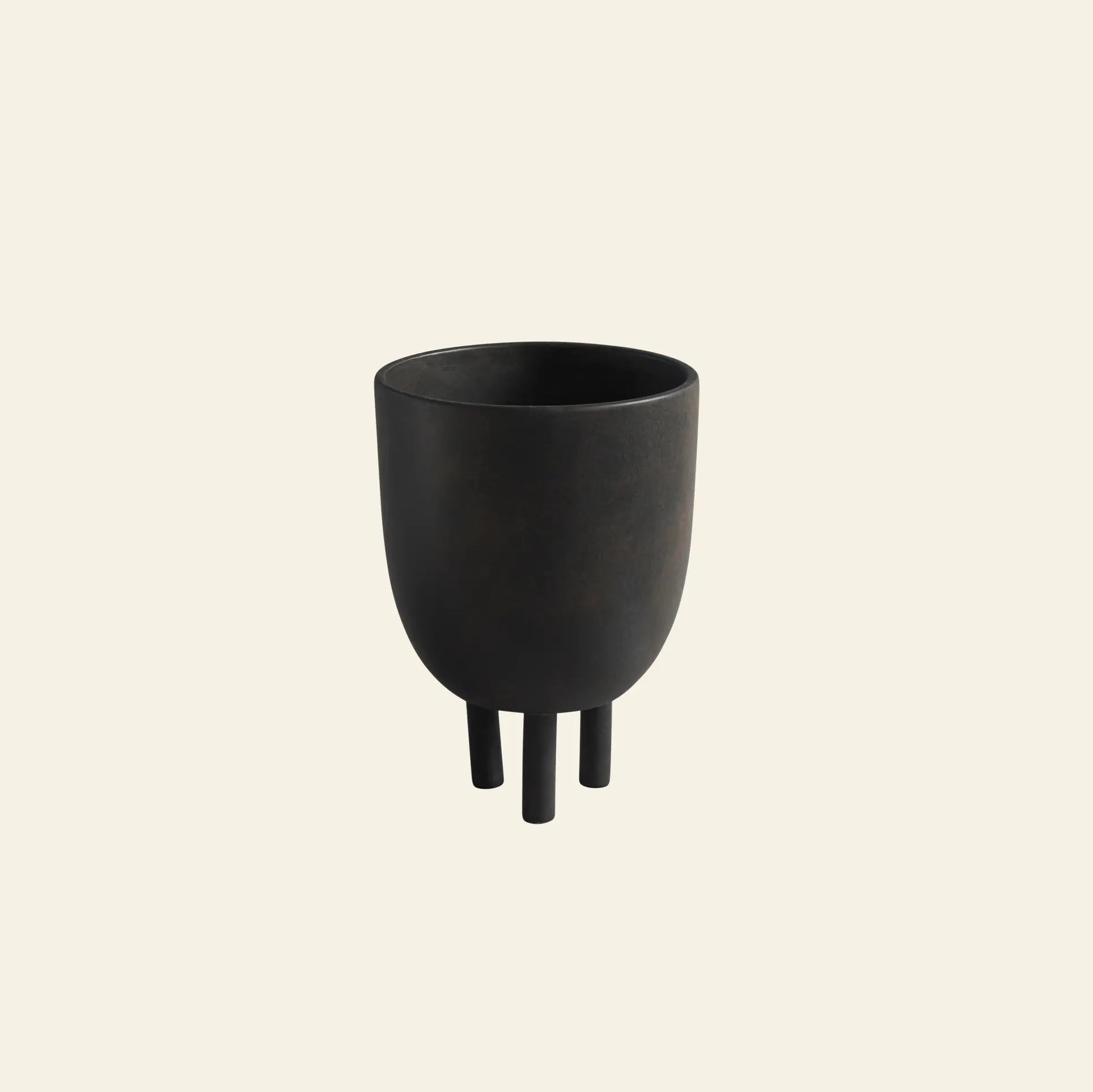The 101 Copenhagen Duck Pot by 101 Copenhagen is a black, rounded, matte-finish planter with three short cylindrical legs, showcasing Scandinavian design against a plain off-white background.