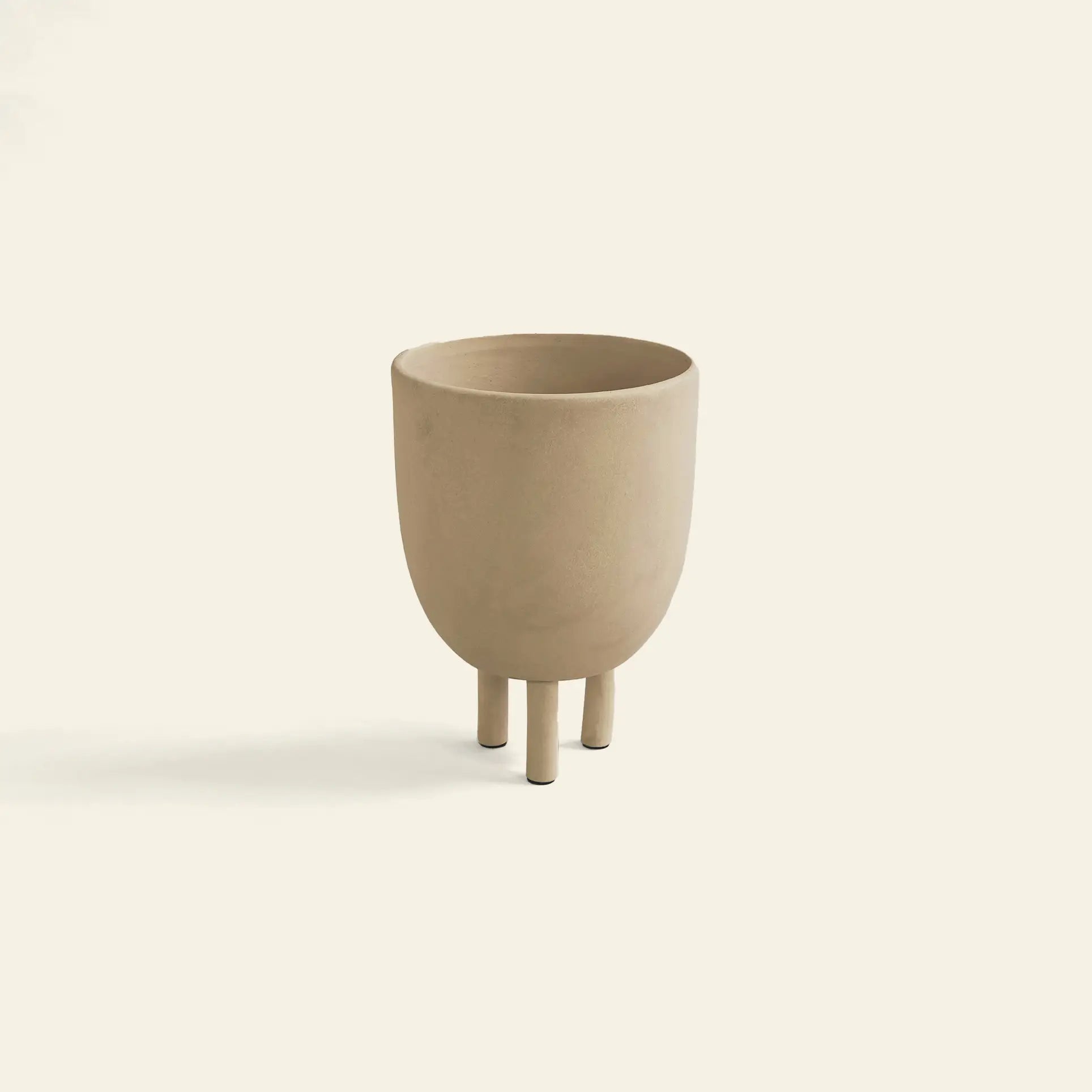 The 101 Copenhagen Duck Pot by 101 Copenhagen is a minimalist beige planter featuring a rounded body and three short legs, adding Scandinavian style and whimsical charm against a plain off-white background.