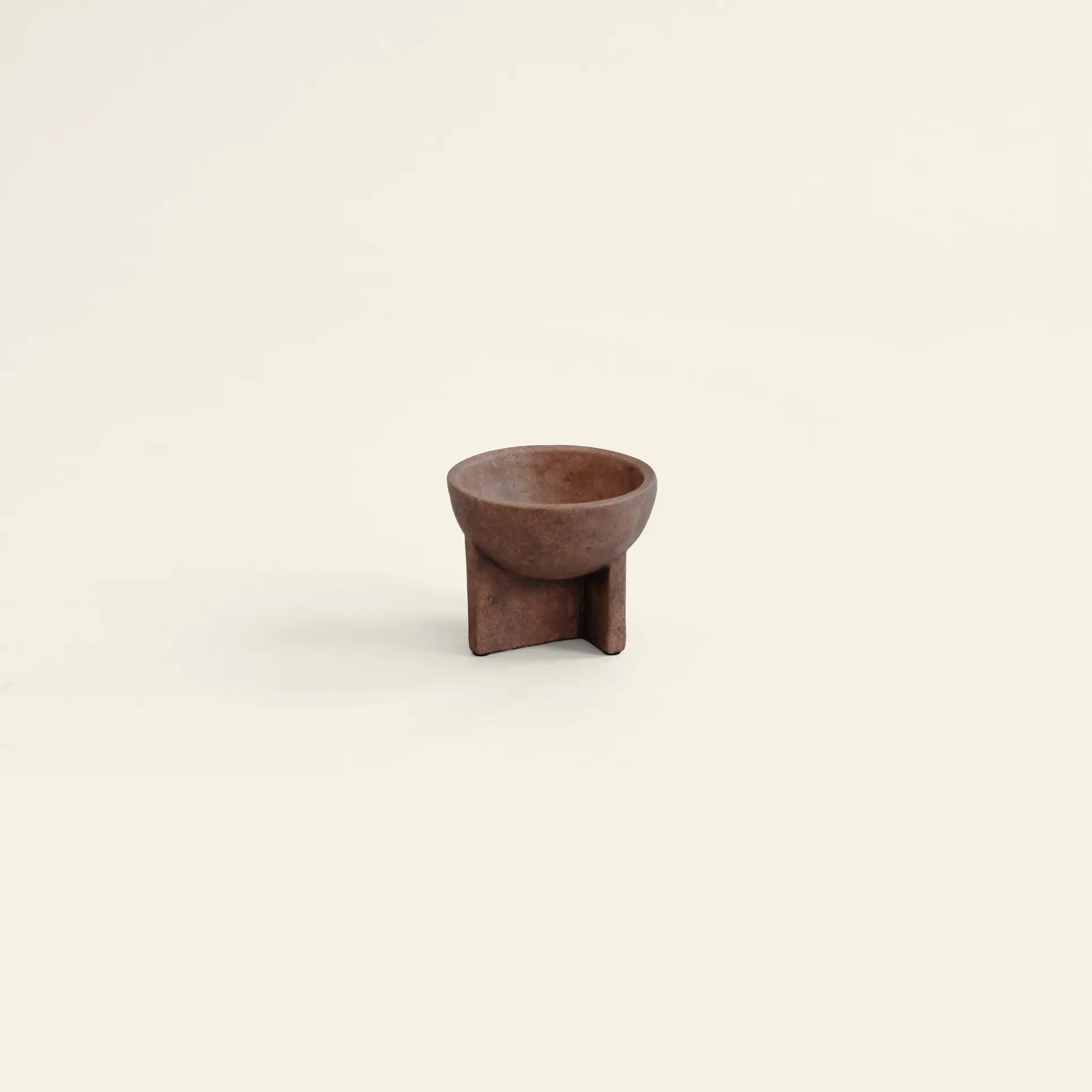 The 101 Copenhagen Osaka Bowl, Mini, by 101 Copenhagen, is a small, round brown ceramic bowl with a distinctive geometric base, showcased centered on a plain light beige background and inspired by sculptural Osaka bowls.