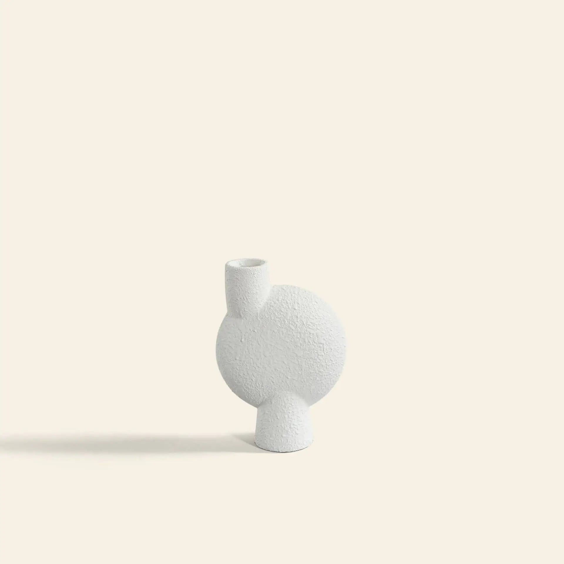 The 101 Copenhagen Sphere Vase Bubl, Medio by 101 Copenhagen is a white, textured ceramic vase with a circular body and short cylindrical neck. Its minimalistic geometric design is ideal for modern home décor and stands out against any background.