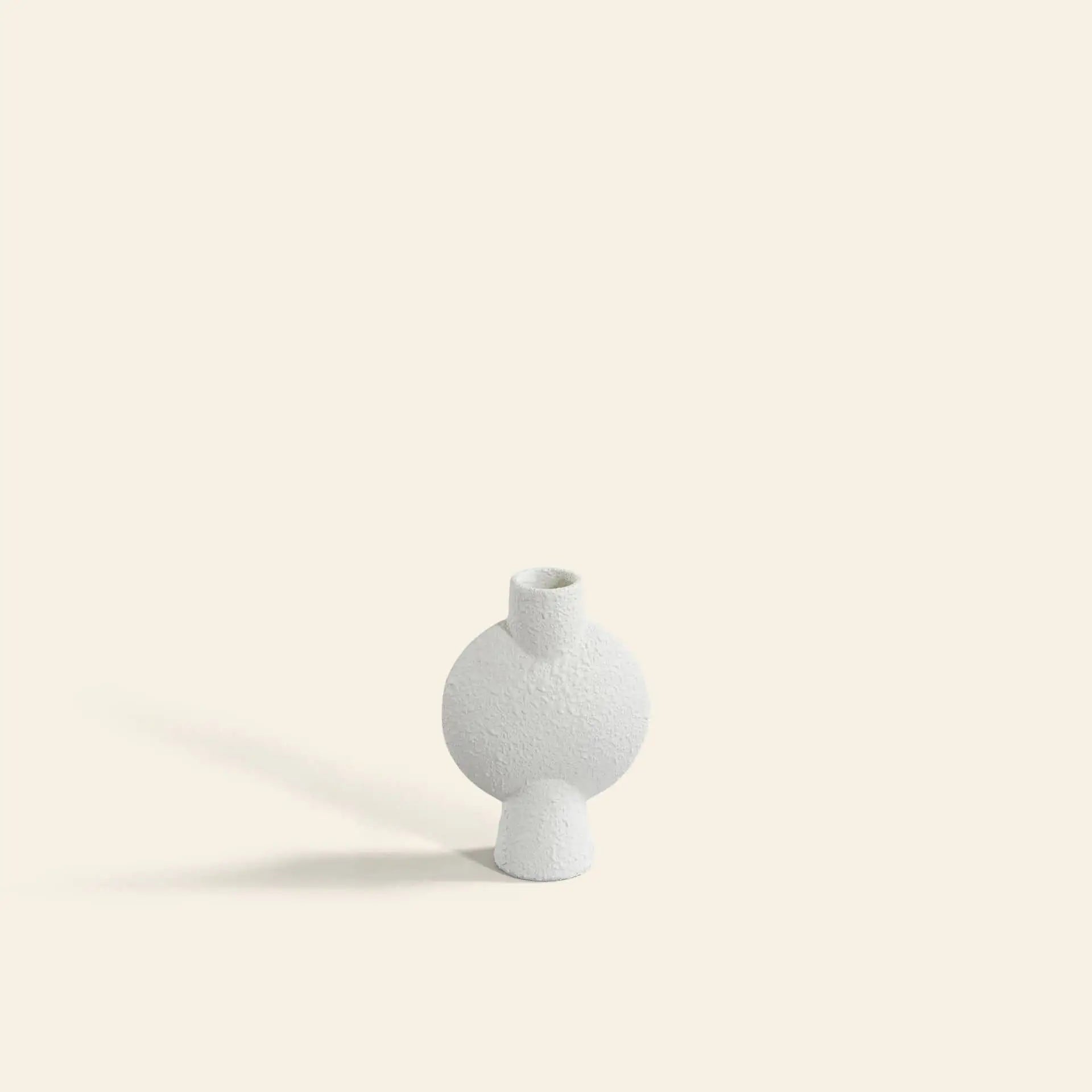 The 101 Copenhagen Sphere Vase Bubl, Mini by 101 Copenhagen is a small, textured white ceramic vase with a geometric round body and narrow neck, shown on a light cream background—ideal for stylish home décor.