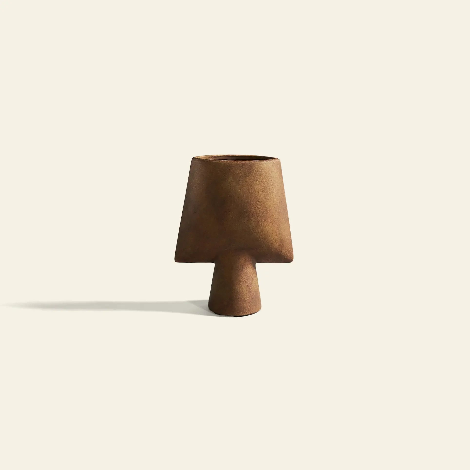 The 101 Copenhagen Sphere Vase Square, Mini by 101 Copenhagen is a brown, cone-shaped ceramic vase with sculptural elegance, featuring a wide base and narrow opening, shown against an off-white background with a subtle shadow.