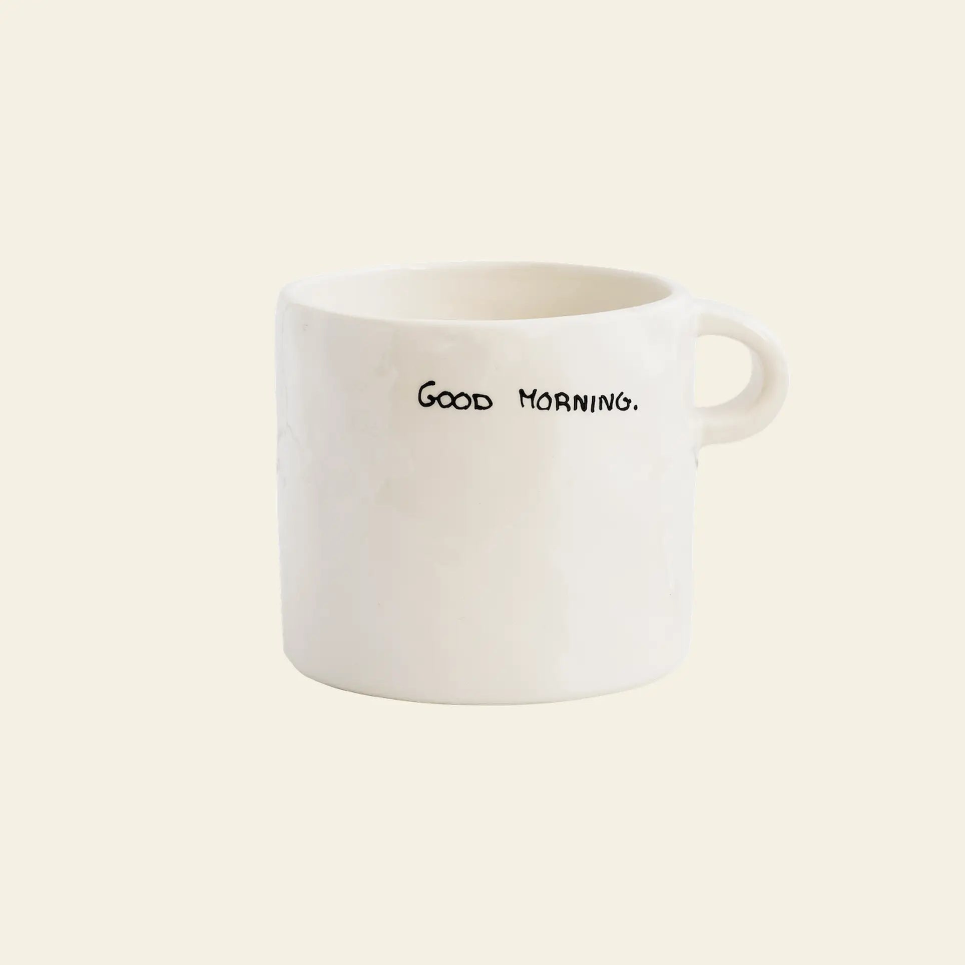 The Anna + Nina Good Morning Mug by Anna + Nina features a handwritten “GOOD MORNING.” in black on plain white ceramic with a small handle—perfect for adding positivity to your daily routine.