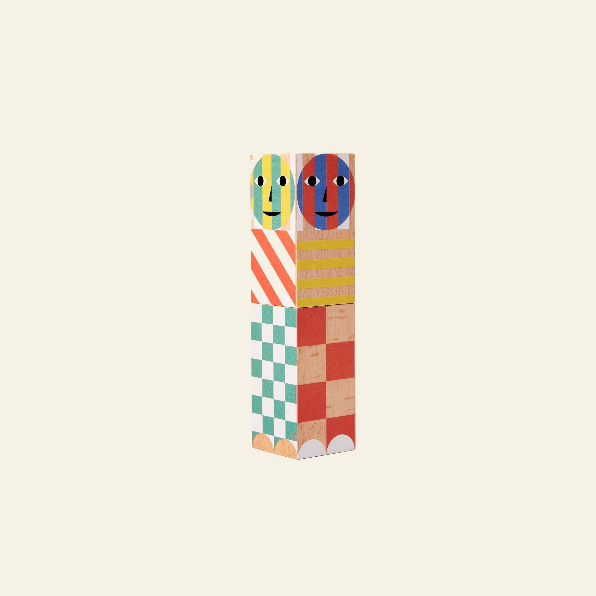 The Areaware Everybody Grinder by Areaware features vibrant geometric patterns and whimsical, round-faced blocks on top, bringing playful charm to any space against a light beige background.