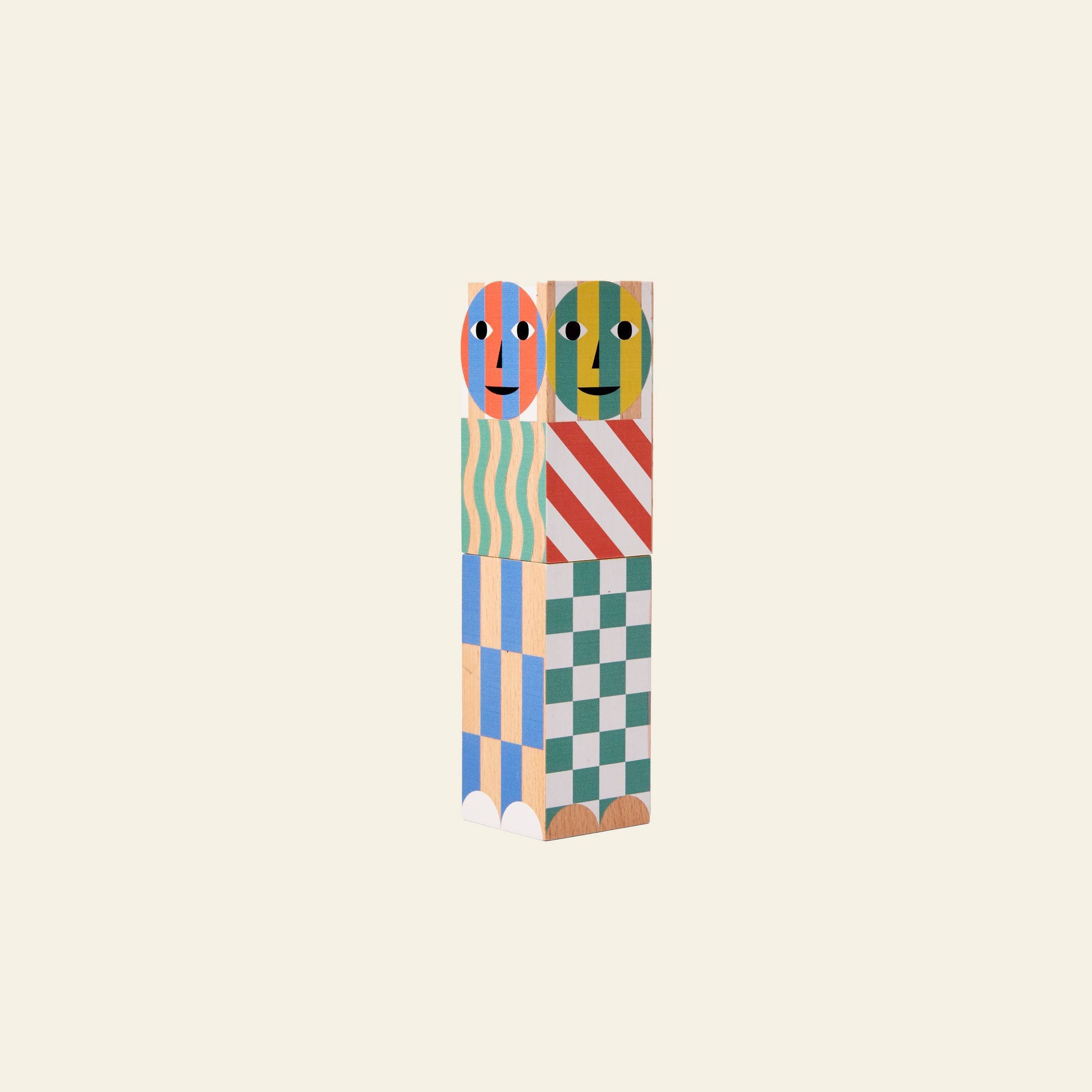 Two colorful Areaware Everybody Grinders by Areaware, stacked vertically with painted faces and playful patterns like stripes and waves, resemble whimsical kitchen tools against a plain cream background.