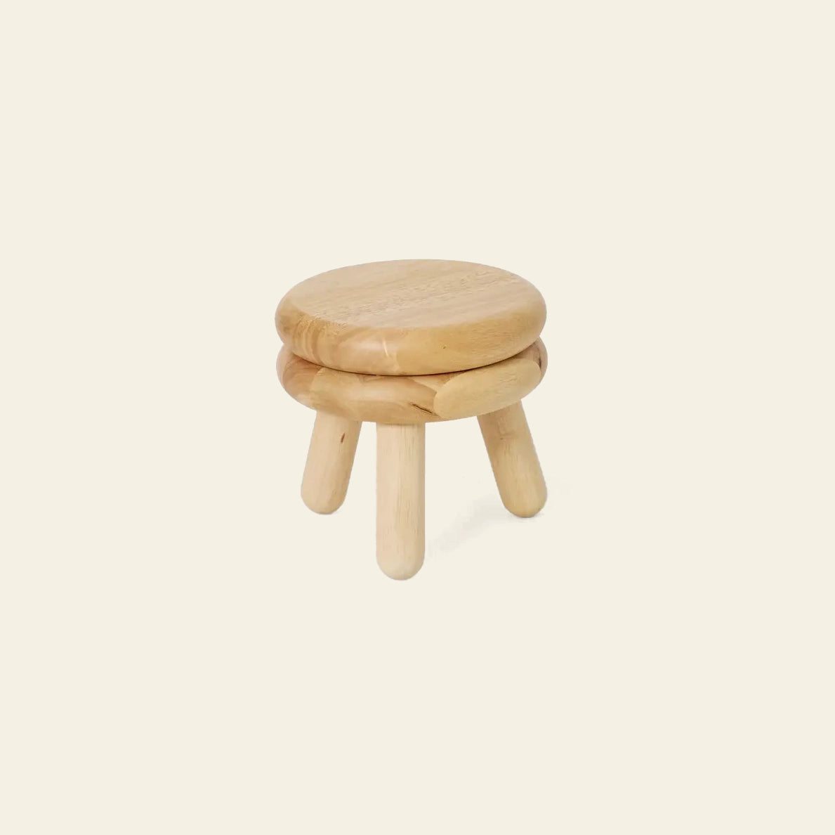 The Areaware Pluma Stool Short by Areaware features a small, round wooden seat atop three legs in light-colored wood. Its contemporary design suits any space and is shown here against a plain beige background.