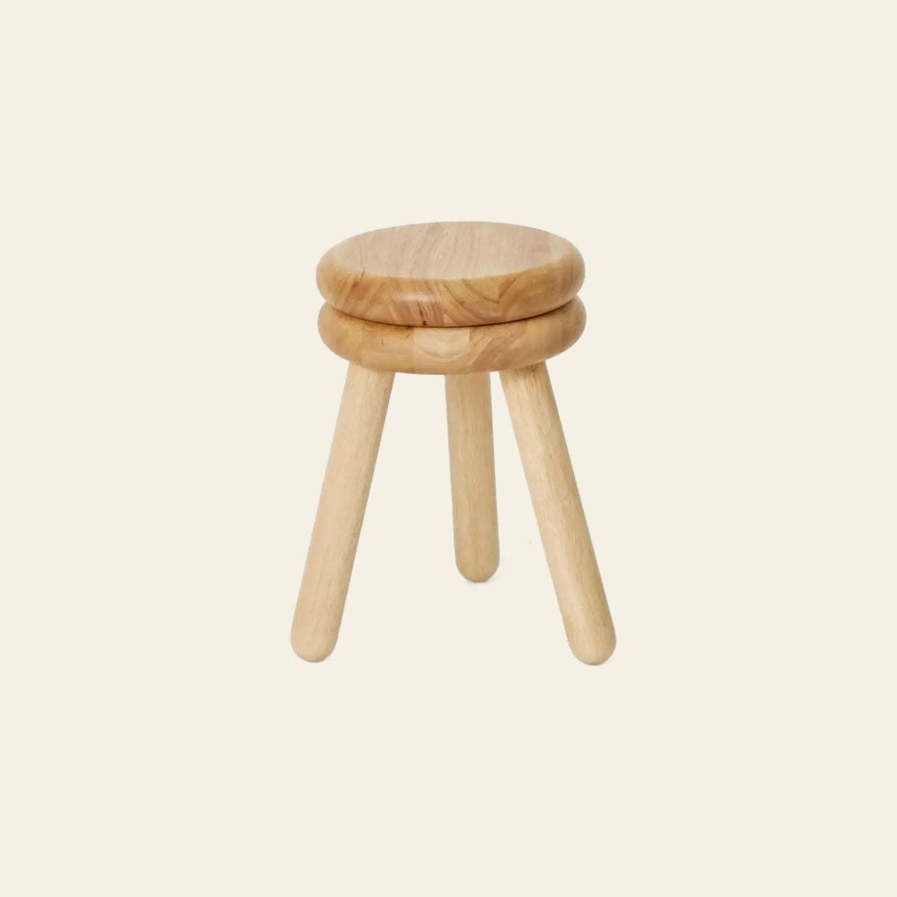 The Areaware Pluma Stool Tall by Areaware is a tall, round three-legged stool in light wood with a minimalist, contemporary design. Its versatile look is highlighted against a plain beige background.
