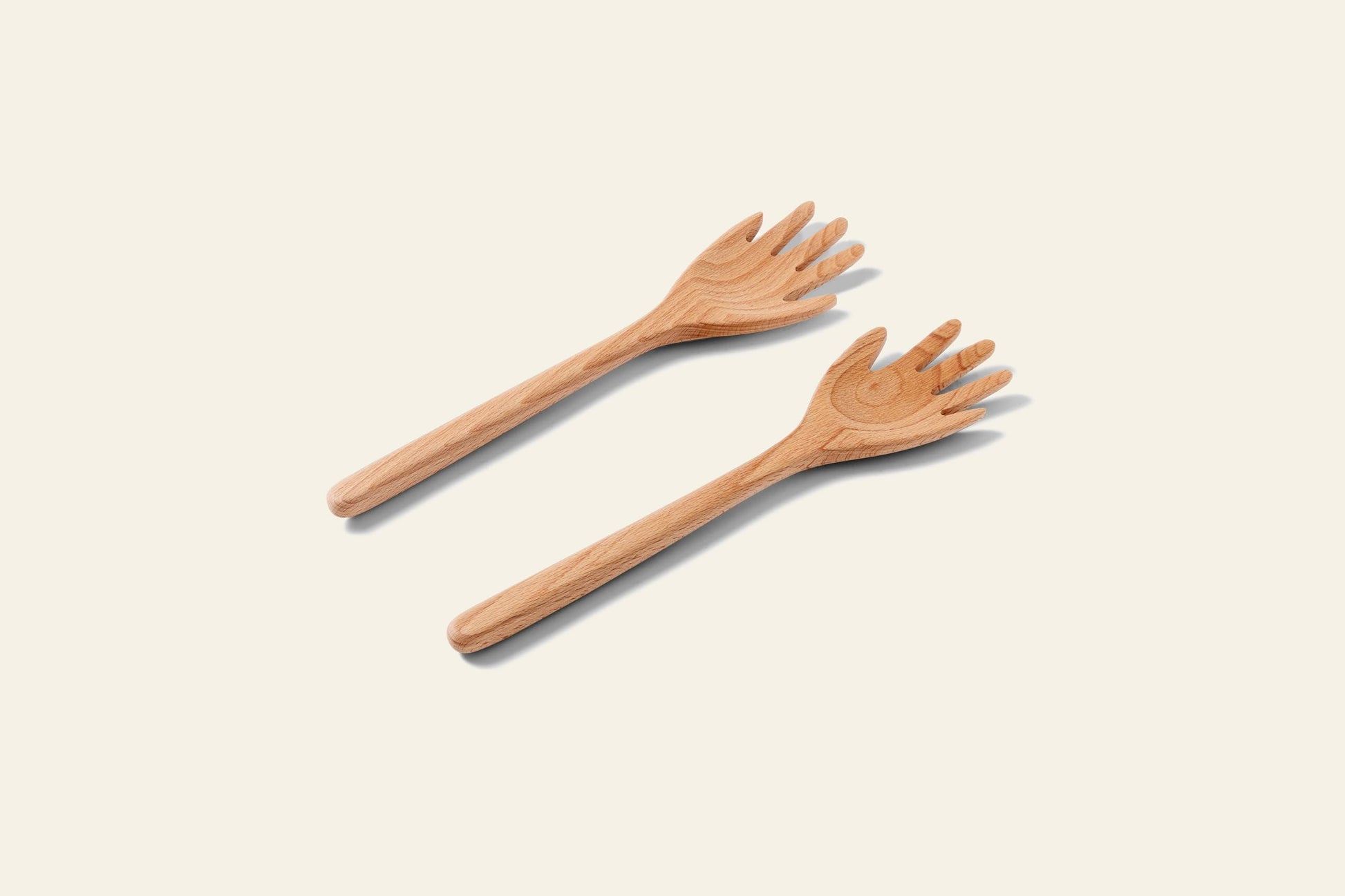 Areaware Serving Friends - Hands by Areaware features two wooden salad servers shaped like hands, placed side by side on a light, neutral background to bring playful design to your dining experience.
