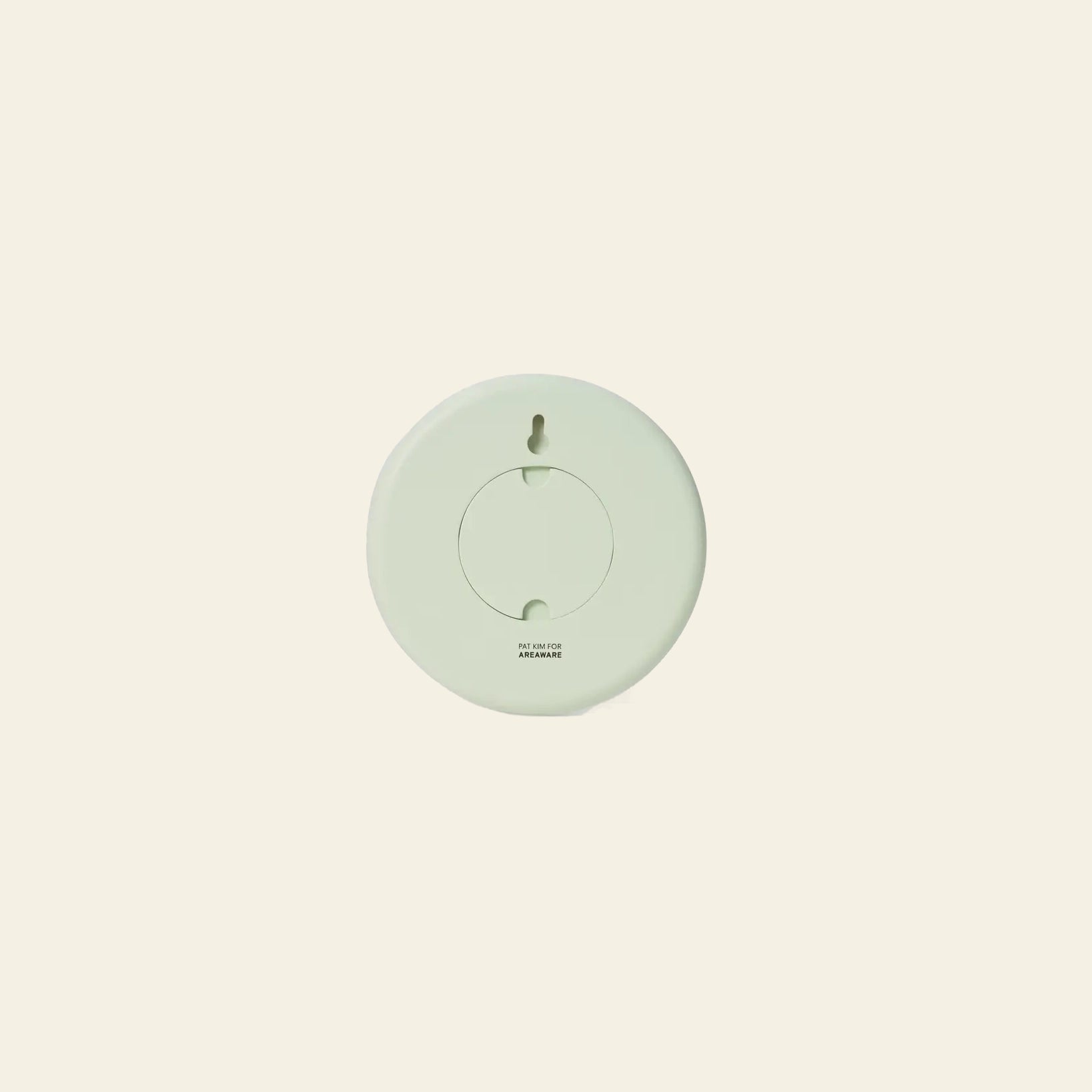 The Areaware Wall Clock by Areaware features a round, light green geometric design with a circular center and is shown against a plain beige background.