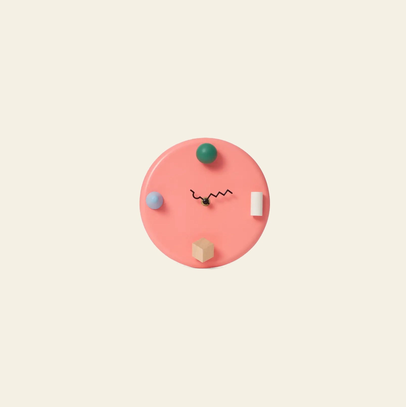 The Areaware Wall Clock by Areaware features abstract pink shapes, a black squiggly hour hand, and geometric hour markers on a light beige background for whimsical timekeeping.