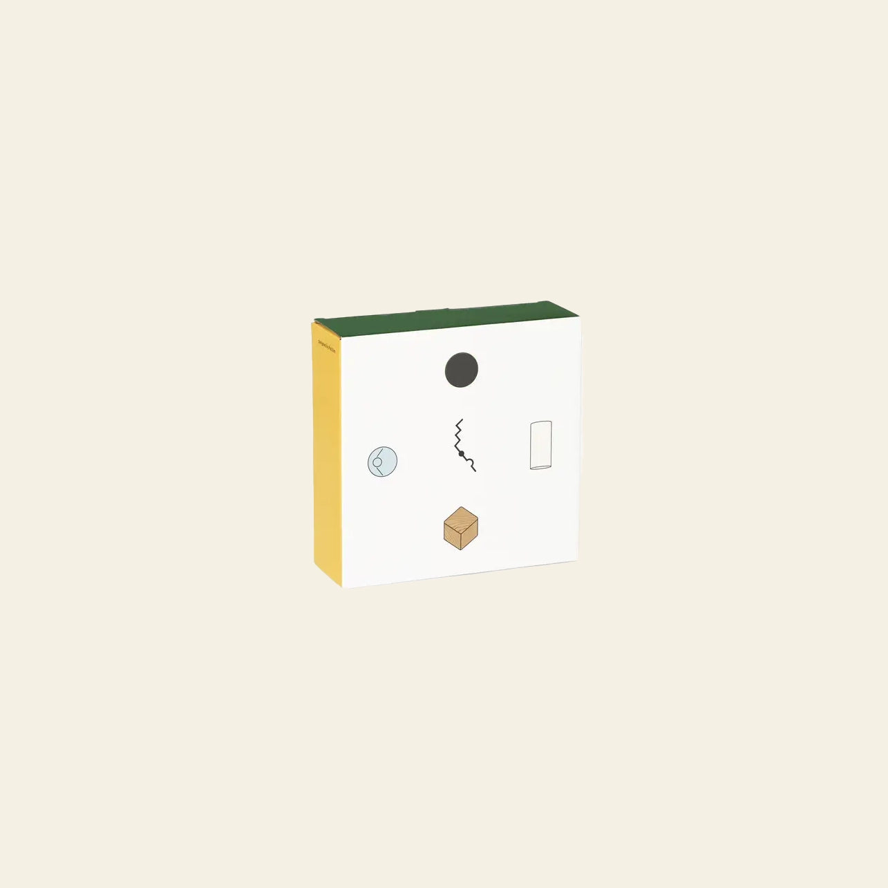The Areaware Wall Clock by Areaware features a minimalist box with a green top, yellow side, and white front adorned with abstract shapes—a black circle, squiggly line, cube, rectangle, and outlined circle—on a plain beige background.