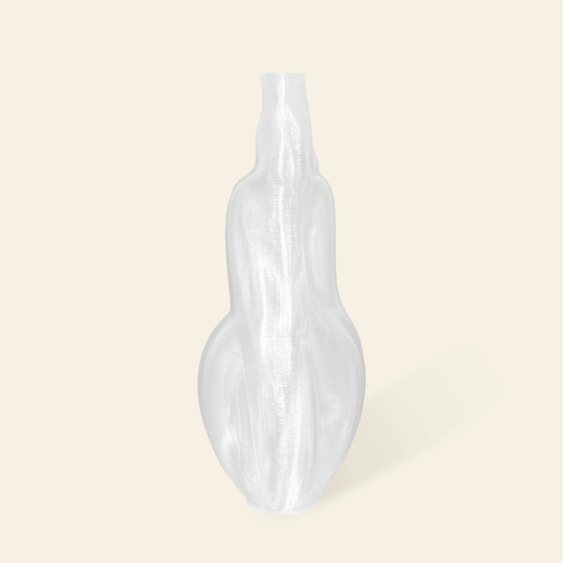 The Argot Studio Éson Vessel, Medium by Argot Studio is a translucent, curvy modern vase with a narrow neck and broad base, standing upright against a light beige background.