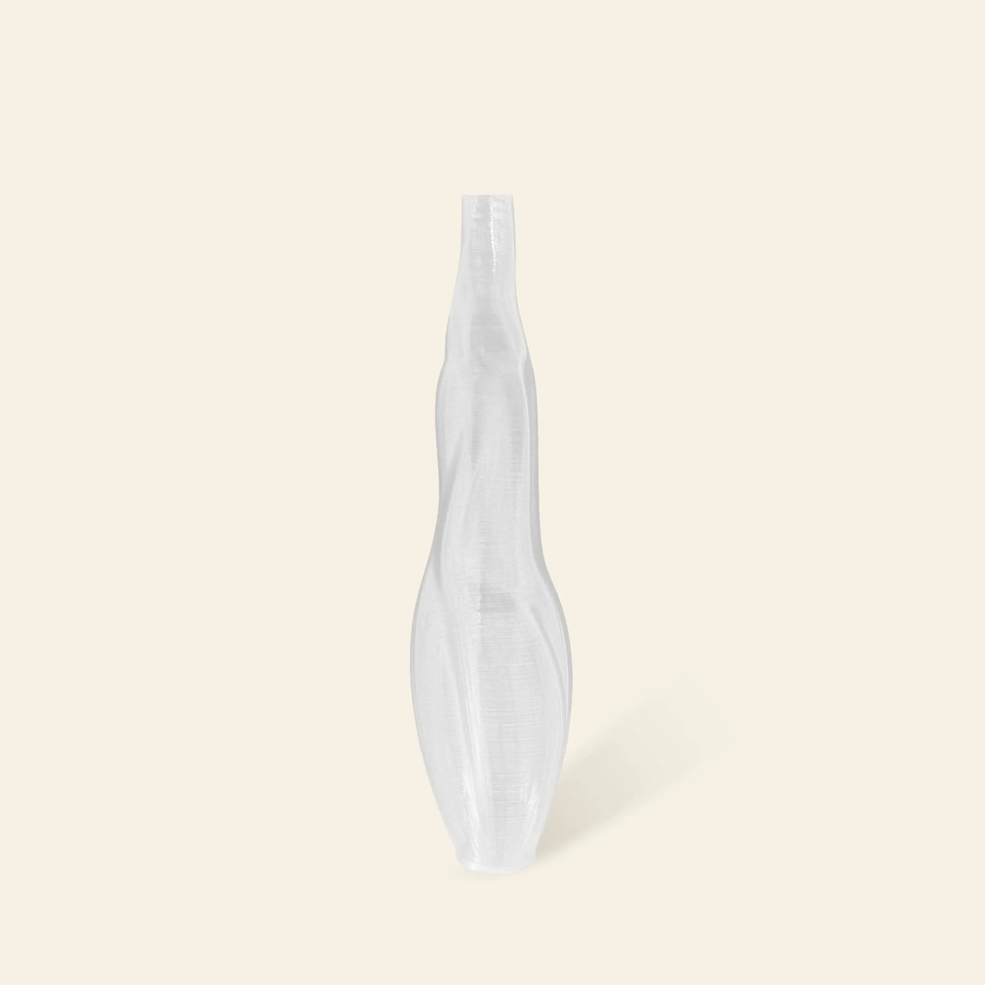 The Argot Studio Éson Vessel, Small—a hand-blown French glass vase with a twisted, sculptural form—stands upright against a plain, light beige background.