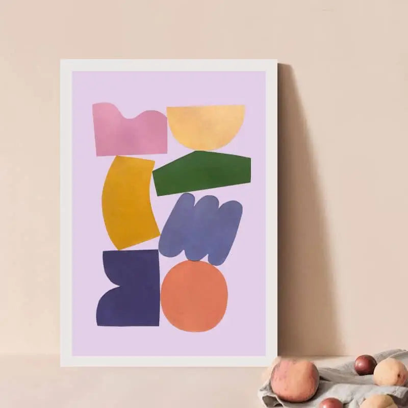Bbblob Balance, 2020, a 30x40 Giclee Print by Bbblob, features colorful abstract geometric shapes. Framed and set against a beige wall with smooth stones, this modern art evokes peaceful vibes through its minimalist collage style.