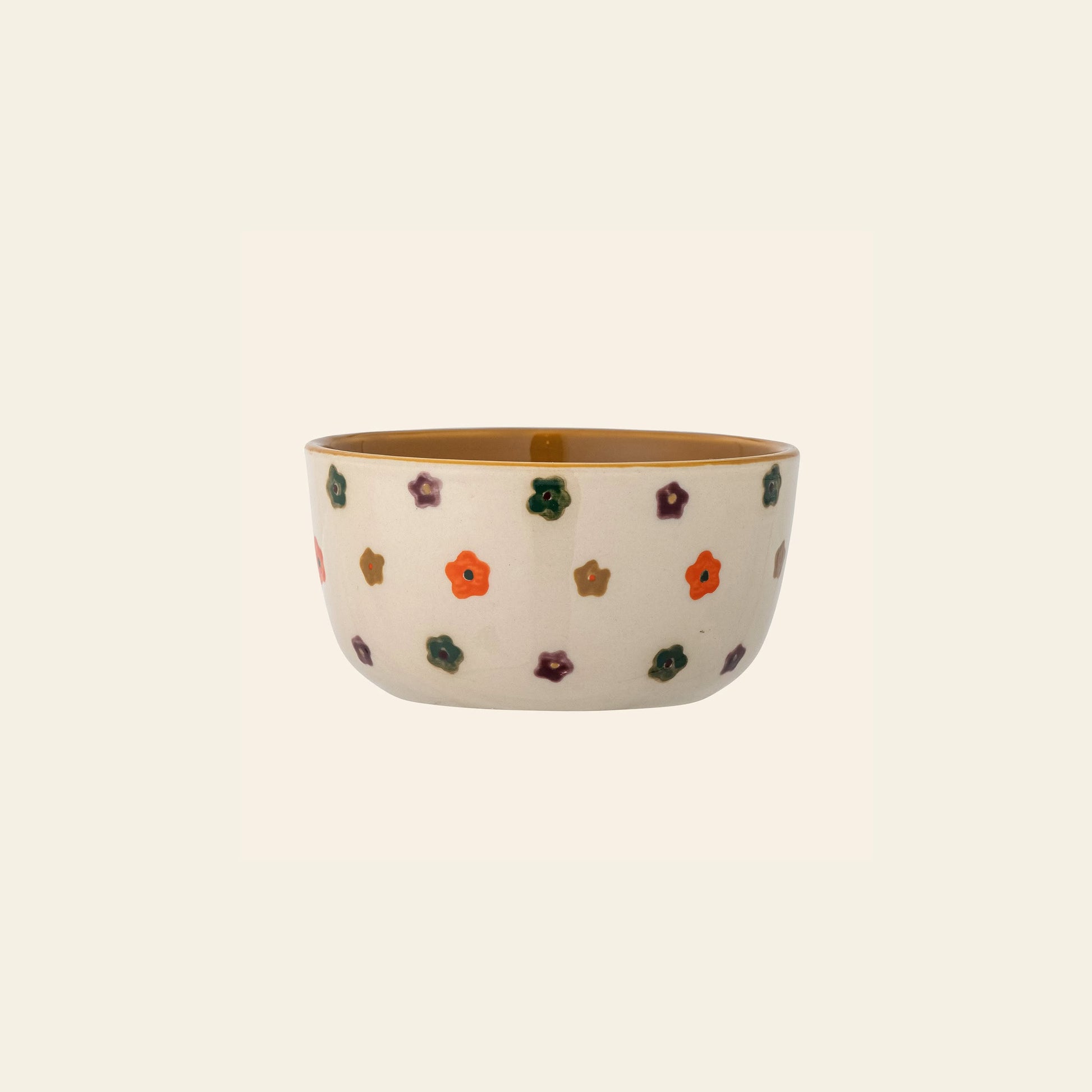 The Bloomingville Addy Bowl is a ceramic children’s bowl with a tan interior, white exterior, and hand-painted orange, purple, green, and brown floral design by Bloomingville, shown centered on a plain light background.