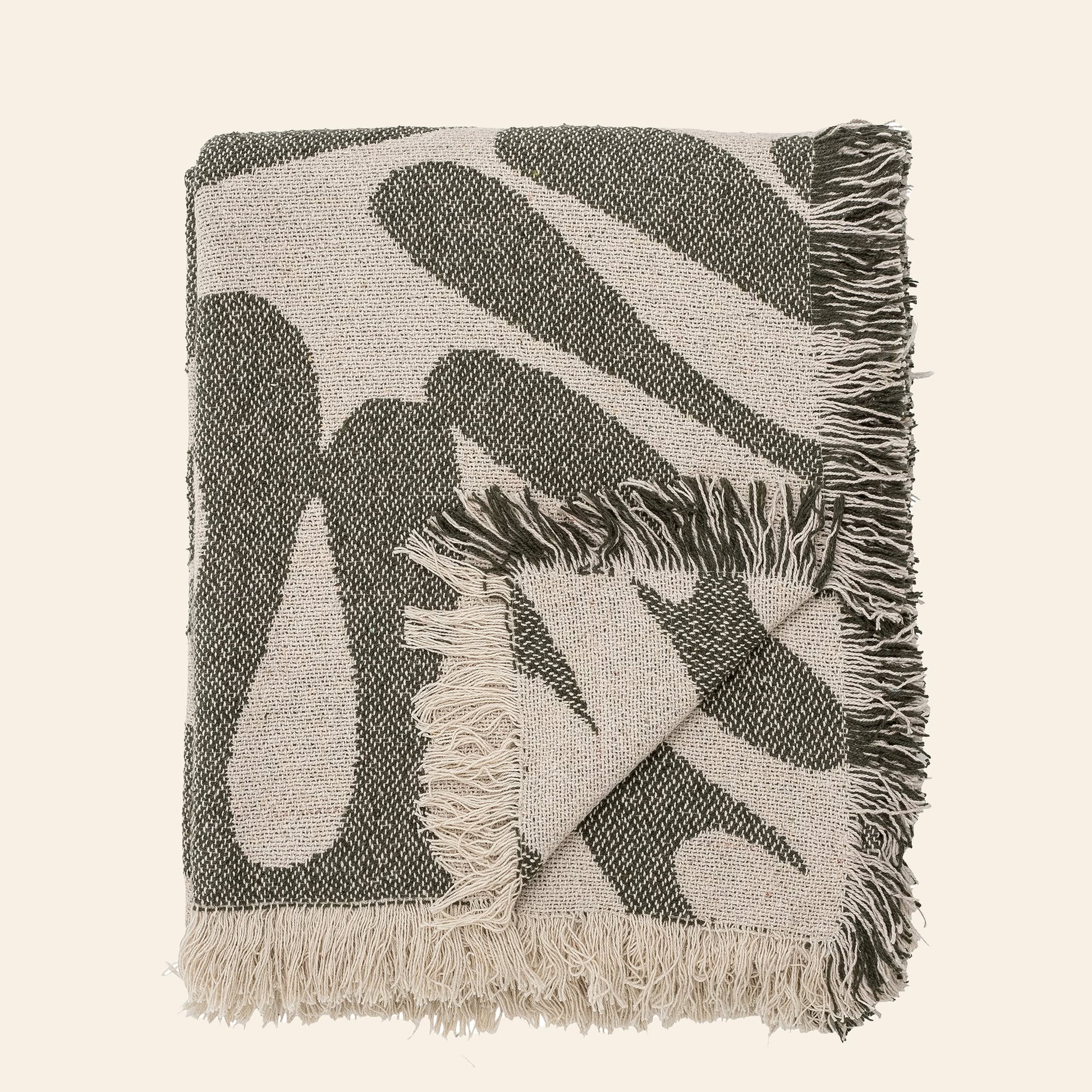 The Bloomingville Alk Throw by Bloomingville is a folded woven blanket made from recycled cotton, featuring a minimalist black and beige pattern with fringed edges, shown against a plain light background.