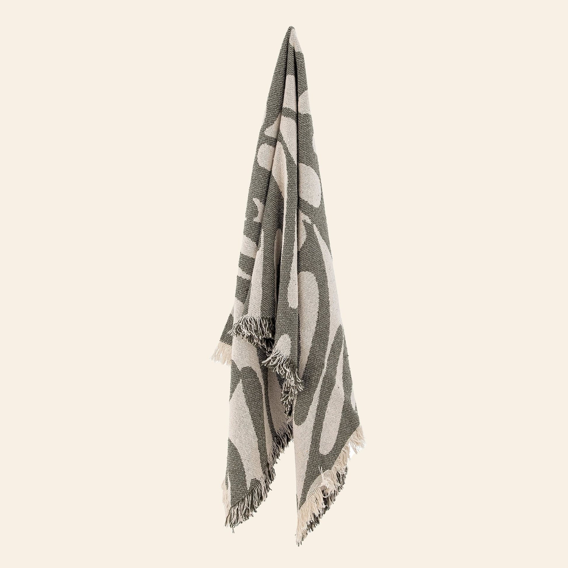 The Bloomingville Alk Throw by Bloomingville features a minimalist woven pattern in green and beige, crafted from recycled cotton with fringed edges, displayed against a plain, light background.