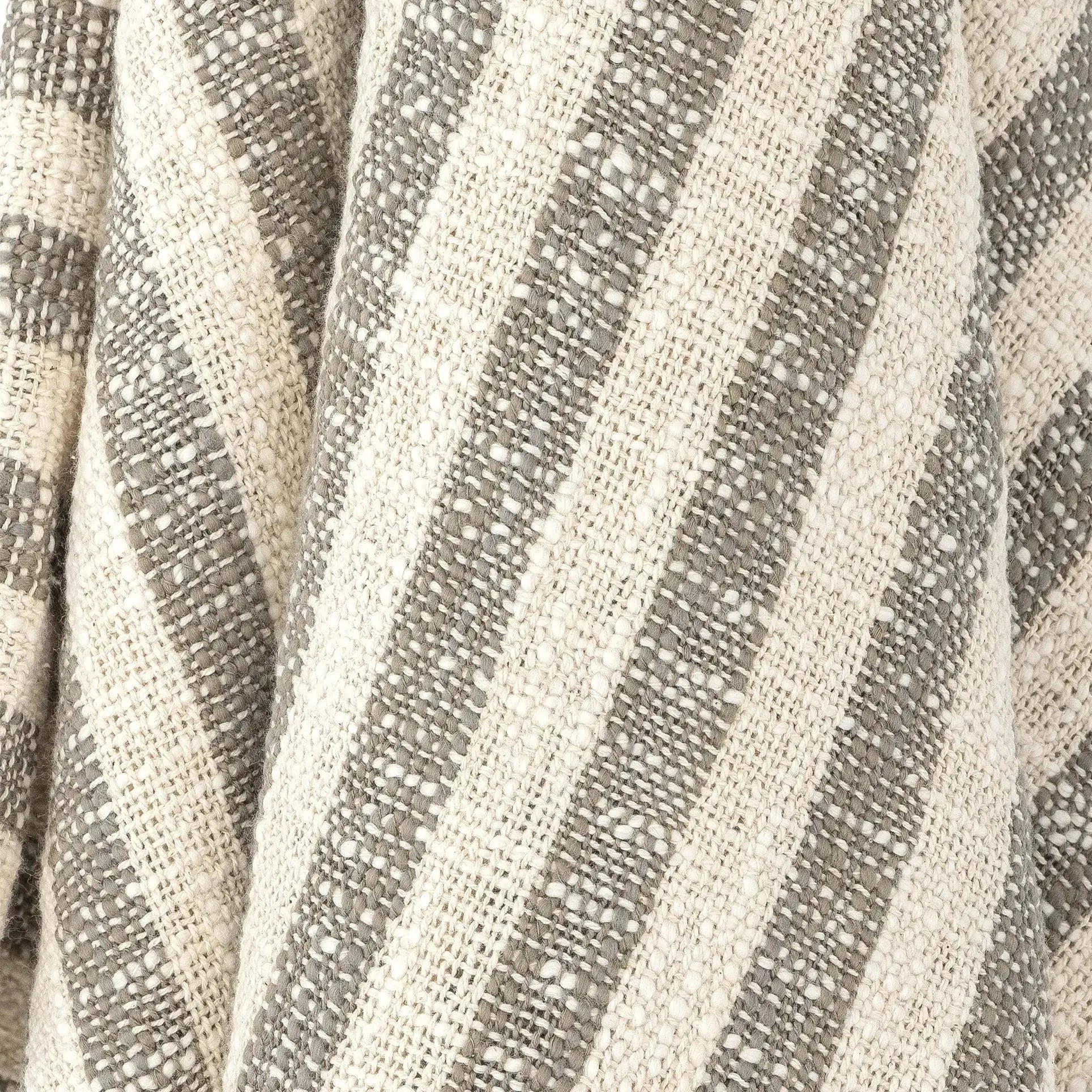 Close-up of the Bloomingville Binnur Throw by Bloomingville, showcasing woven cotton fabric with alternating beige and gray vertical stripes, a subtle texture, and minimalist style.