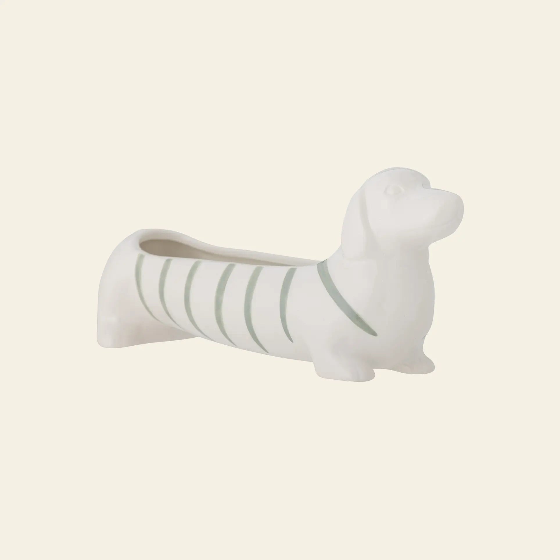 The Bloomingville Djaco Bowl by Bloomingville is a white ceramic bowl shaped like a dachshund with light green stripes, ideal for decorative storage and display.