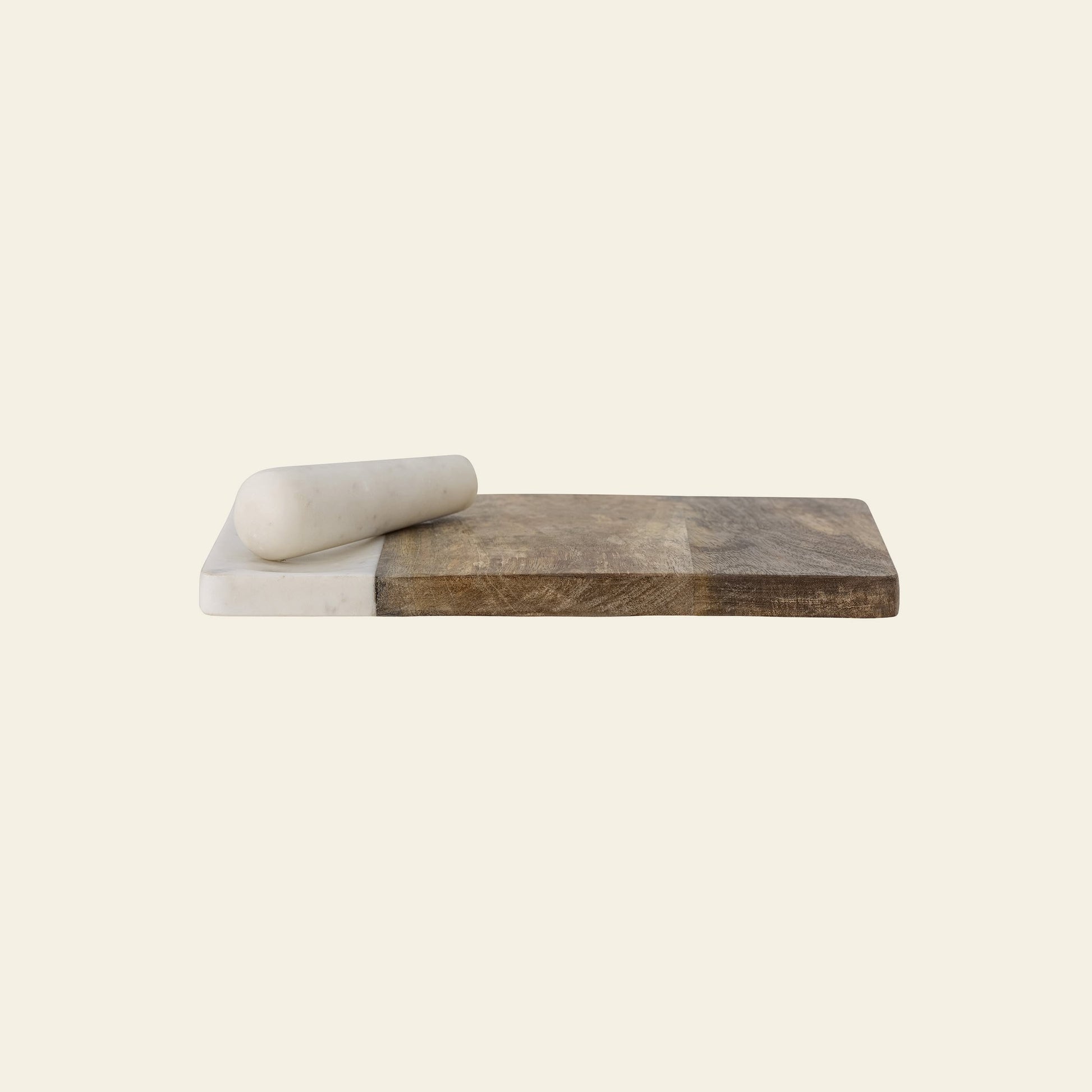 The Bloomingville Havannah Cutting Board w/Pestle by Bloomingville features elegant marble and natural mango wood, with a marble pestle resting on the rectangular board, set against a simple, light background.