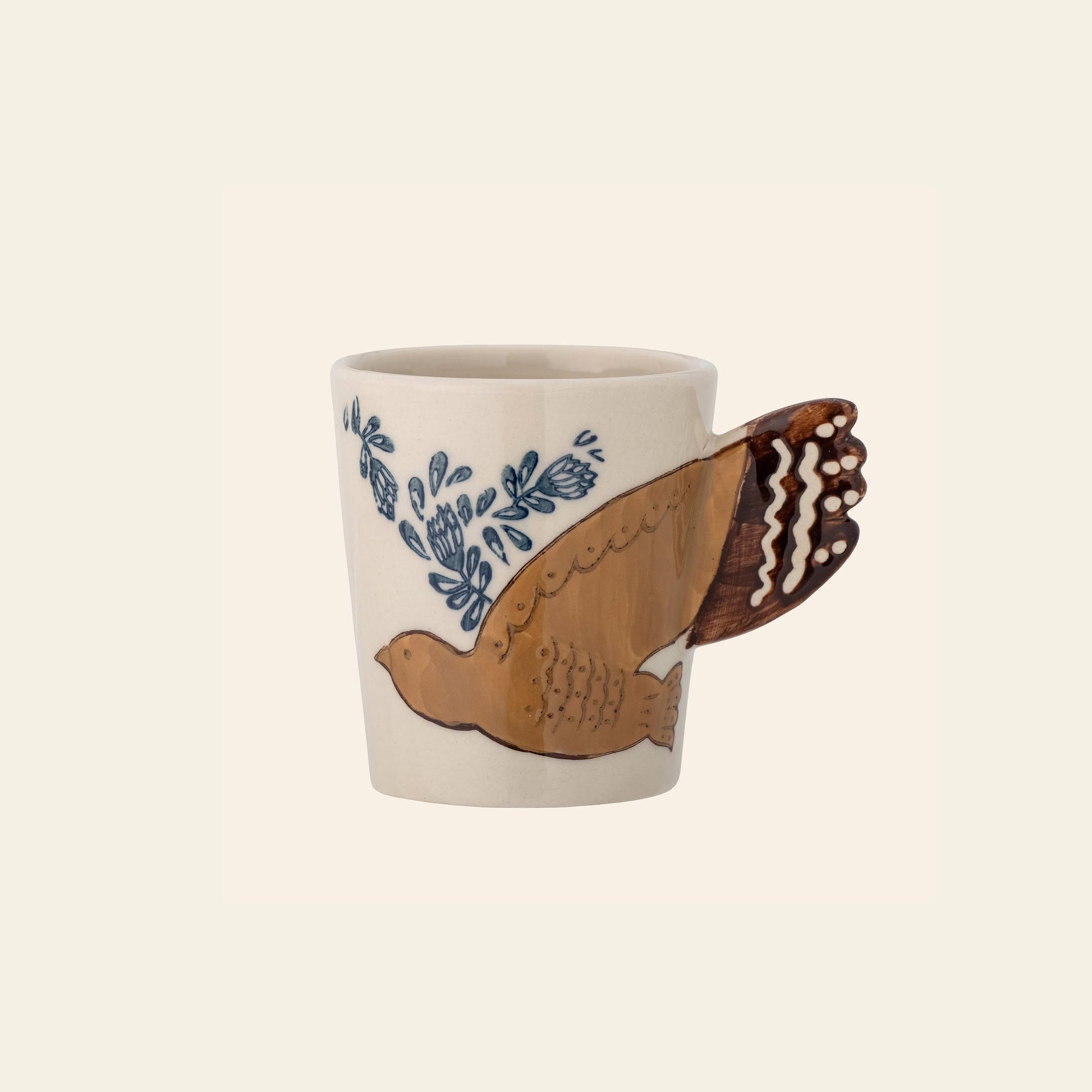 The Bloomingville Hezha Cup - Nature by Bloomingville is a cream-colored stoneware mug with a sculpted bird handle and blue floral accents near the head on a light beige background.