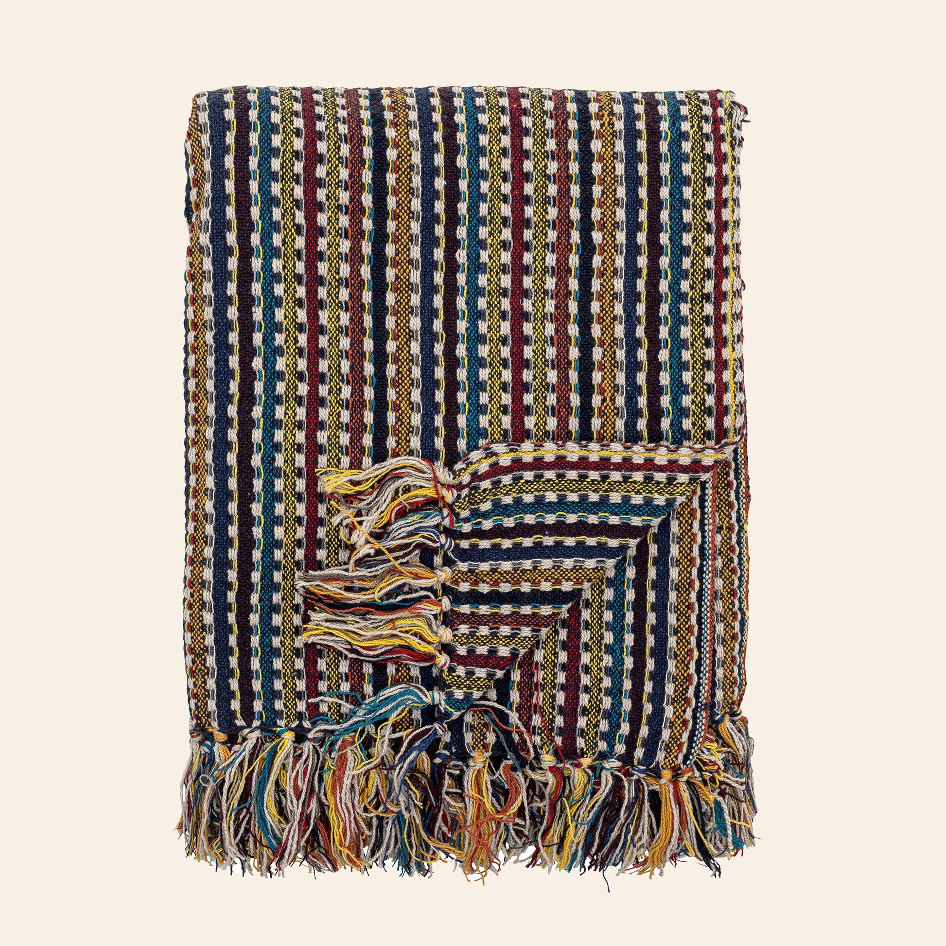 The Bloomingville Lazzario Throw by Bloomingville is a folded woven blanket with red, yellow, green, blue, and white geometric stripes, fringed edges, and textured patterns—ideal for adding a cozy layer to any room.