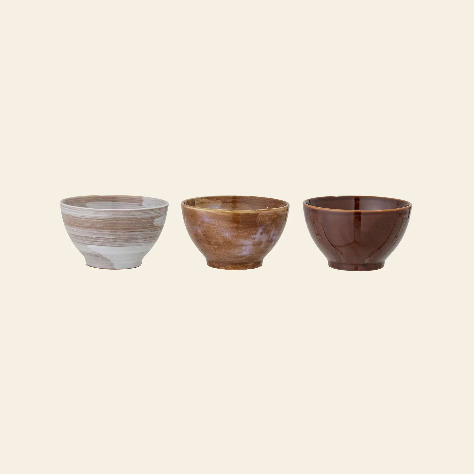 The Bloomingville Lotus Bowl Set of 3 features stoneware bowls in light gray with white swirls, marbled beige and brown, and glossy dark brown, displayed side by side on an off-white background.