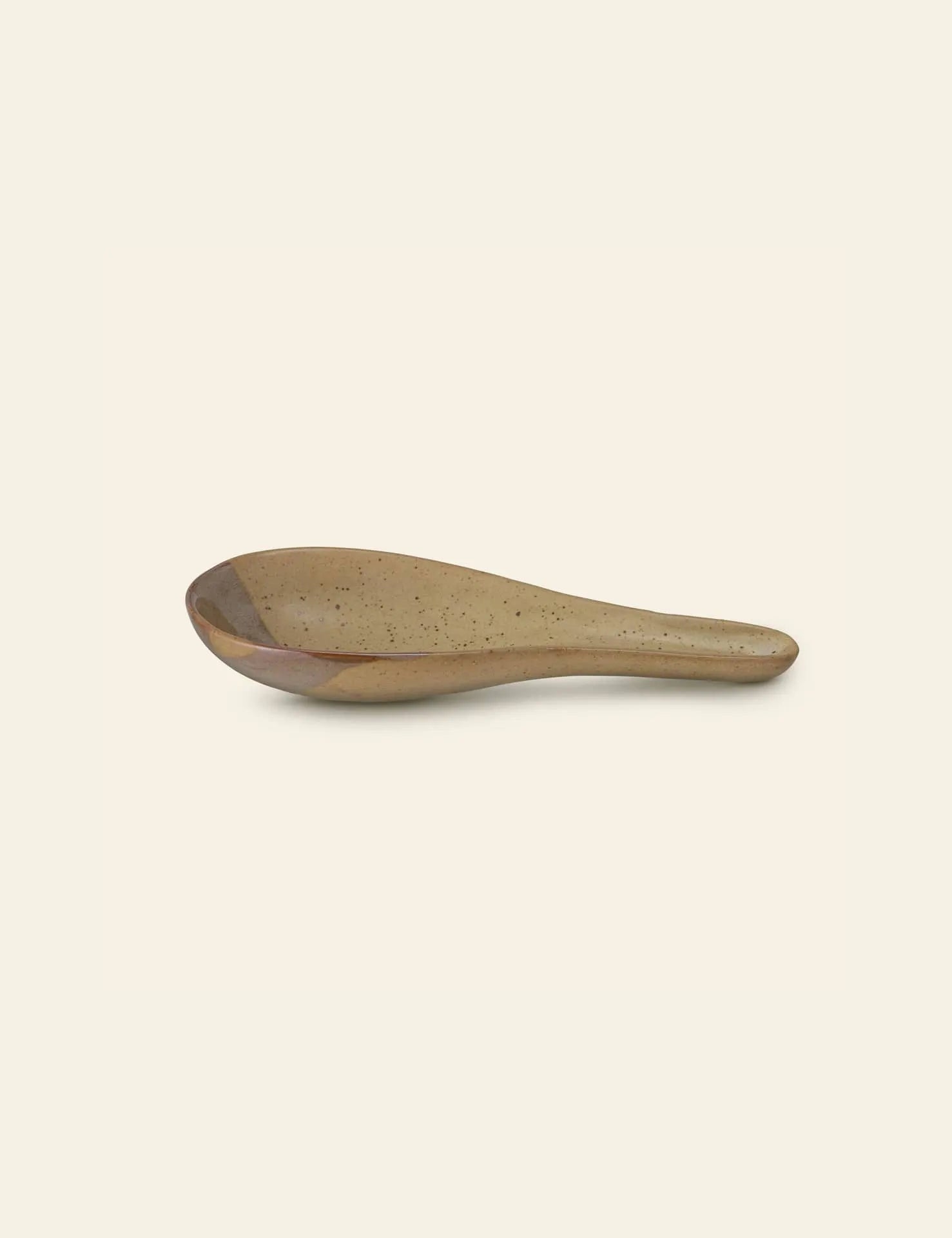 The Bloomingville Masami Spoon Rest features a speckled brown glaze, bringing style to your kitchen. Presented against a plain off-white background.