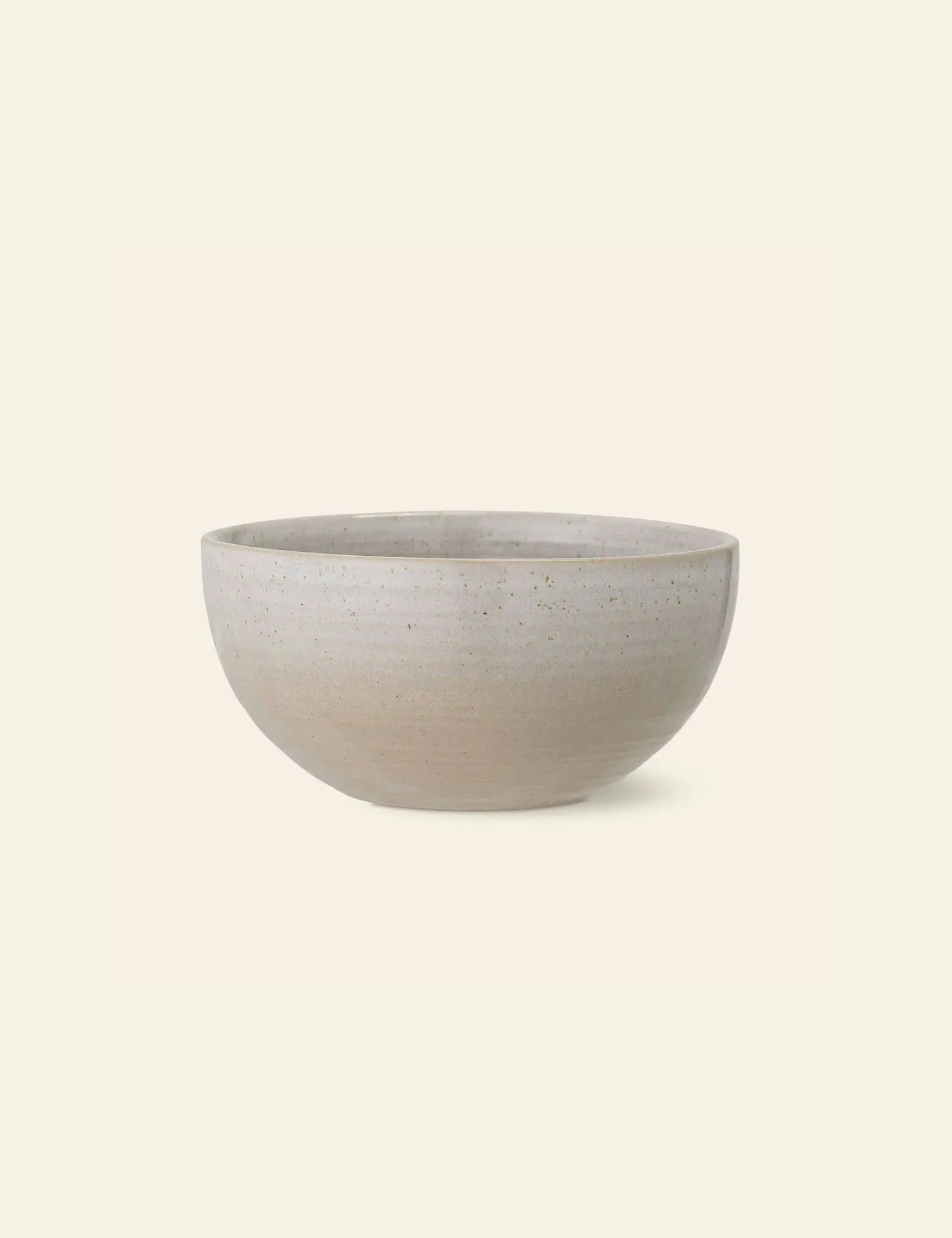 The Bloomingville Taupe Bowl by Bloomingville is a simple, round, durable natural stoneware bowl in light beige with a smooth matte finish and subtle speckled texture, shown against an off-white background.