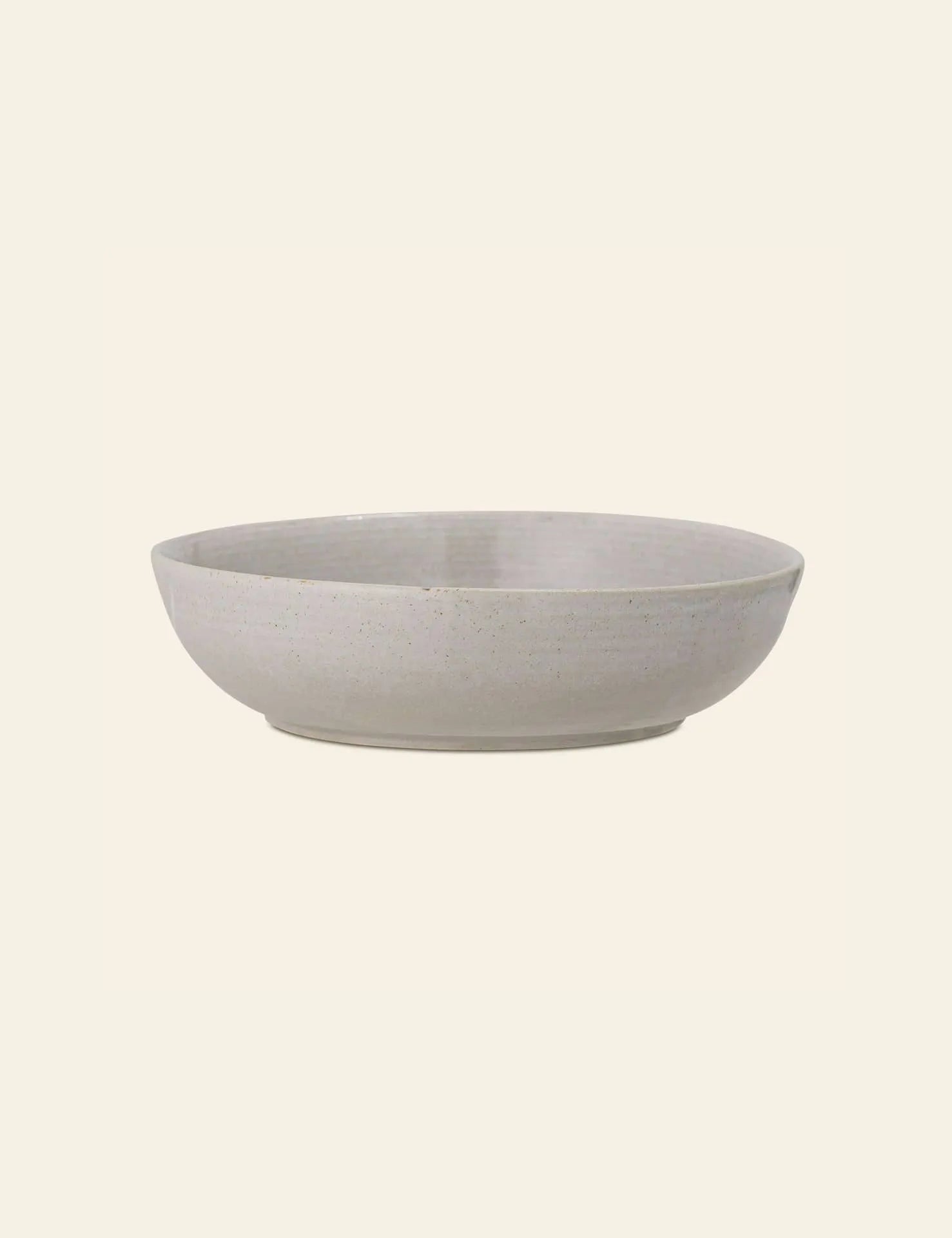 The Bloomingville Taupe Serving Bowl by Bloomingville is a shallow, round ceramic bowl with a matte, light grey natural finish, displayed against a plain off-white background.