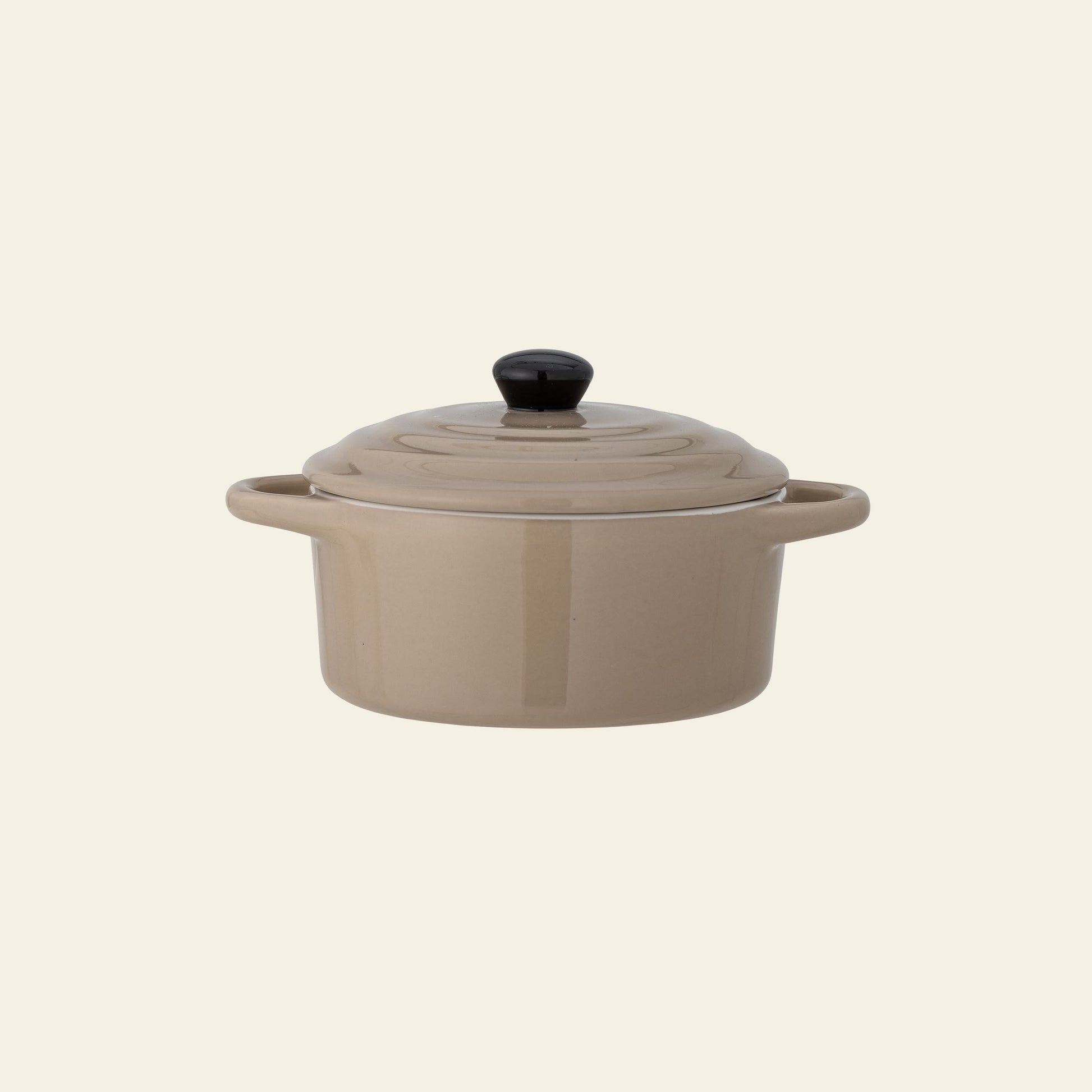 The Bloomingville Thanos Oven Dish w/Lid by Bloomingville is a beige stoneware dish with side handles and a matching lid with black knob, ideal for casseroles, shown on a plain light background.