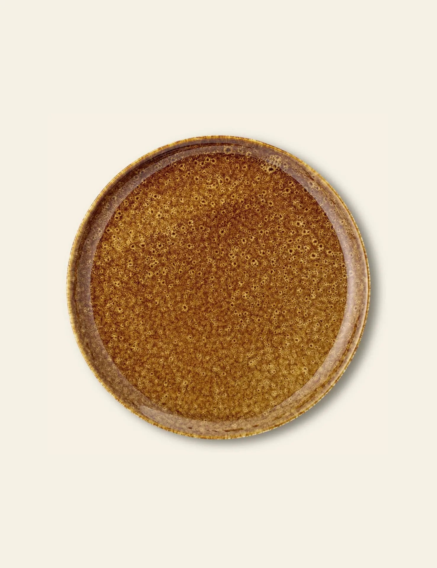 The Bloomingville Thea Plate is a round, brown stoneware plate with a speckled, glazed texture and rustic design by Bloomingville, shown against a light beige background.
