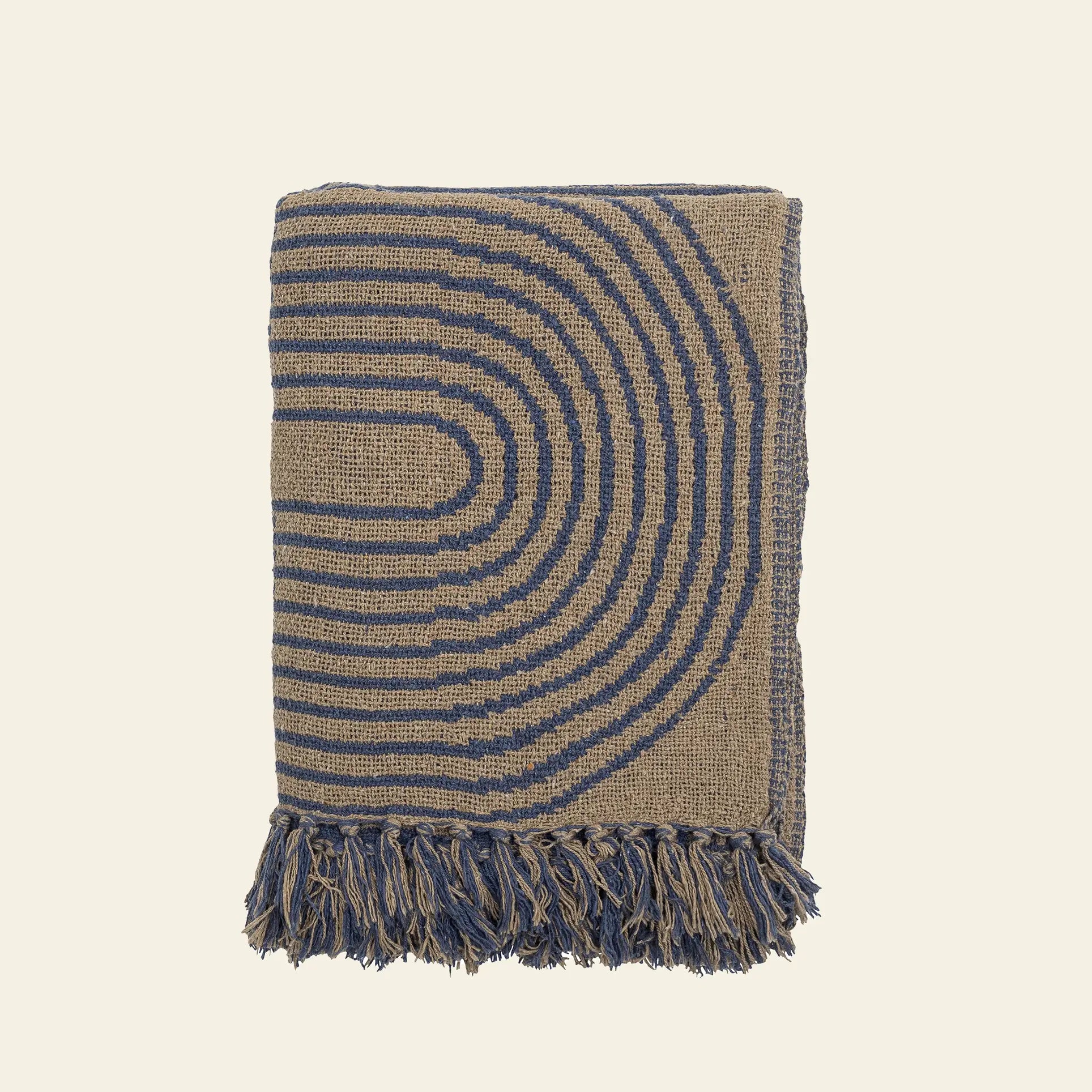 The Bloomingville Tiffanie Throw by Bloomingville is a folded blue and beige cotton blanket with a repeating semicircular arch pattern and blue fringed tassels along the bottom edge, shown on a plain background.
