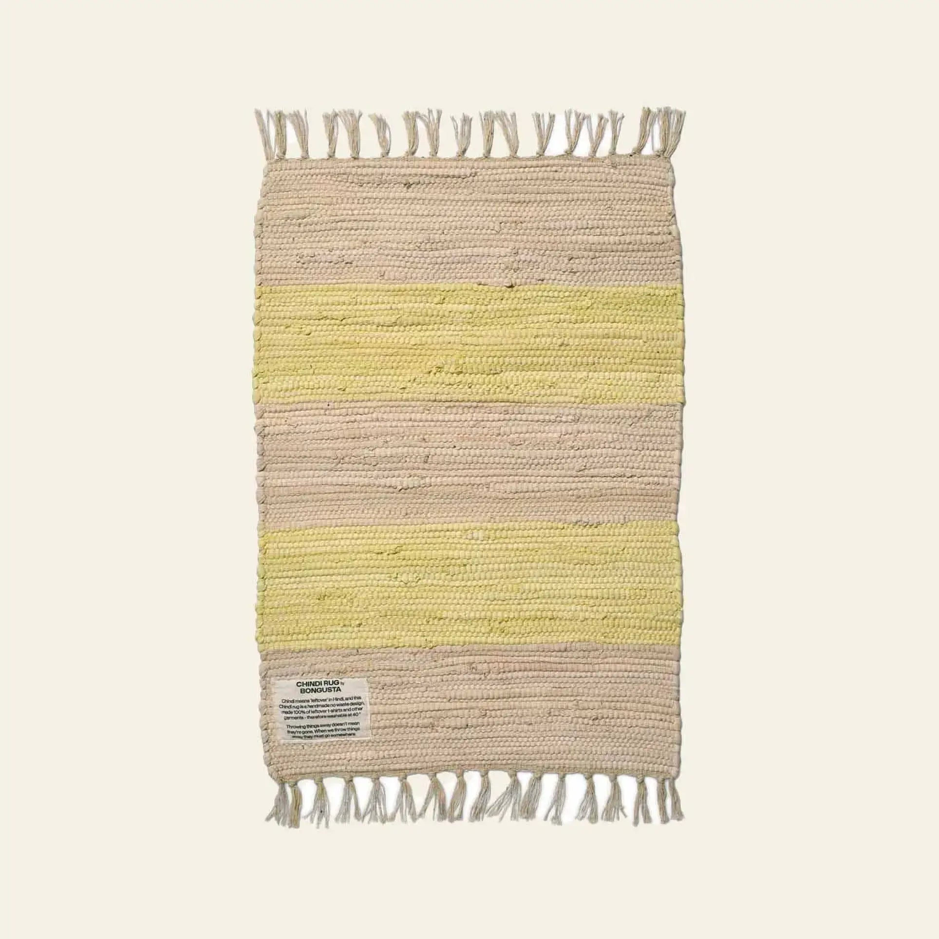 The Bongusta Chindi Rug (45x60) by Bongusta is handcrafted in India from surplus cotton, featuring alternating beige and pale yellow stripes, fringed shorter sides, and a small corner label, shown on a neutral background.