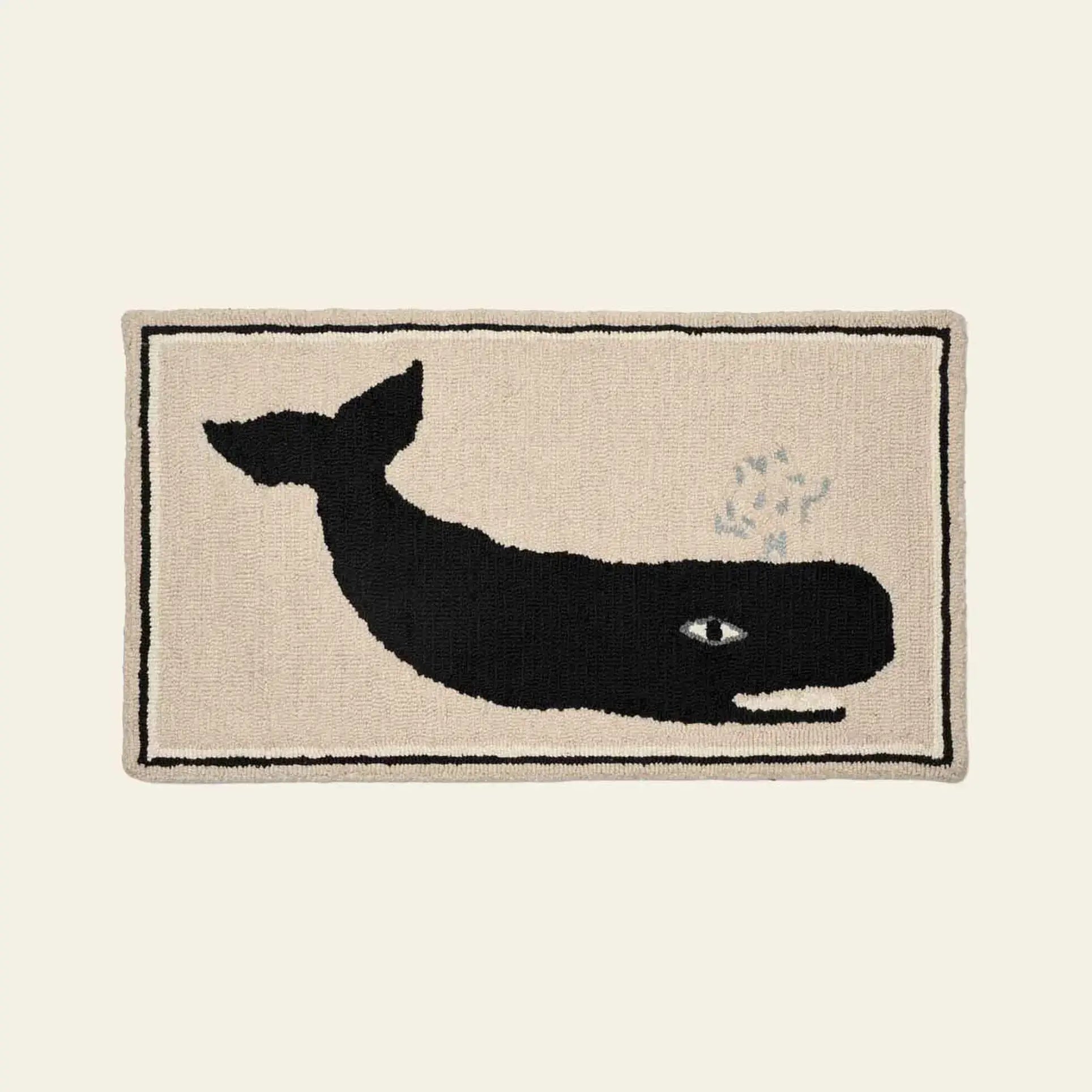 The Bongusta Frame Rug by Bongusta showcases a large black whale with a visible eye and spout on beige, bordered by a slim black line—a creative choice for unique wall decor.