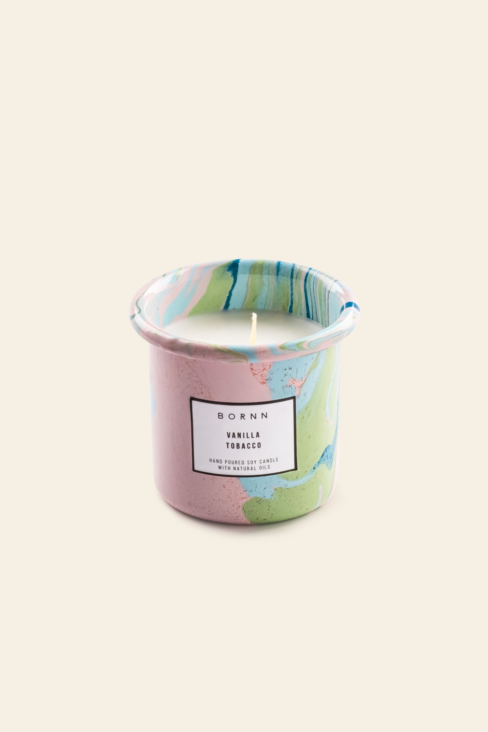 The Bornn Enamelware Candle Tobacco-Vanilla by Bornn Enamelware comes in a colorful marbled container with pink, green, and blue shades, featuring a label: “BORN N Vanilla Tobacco, Hand Poured Scented Candle with Natural Soy Wax.”.