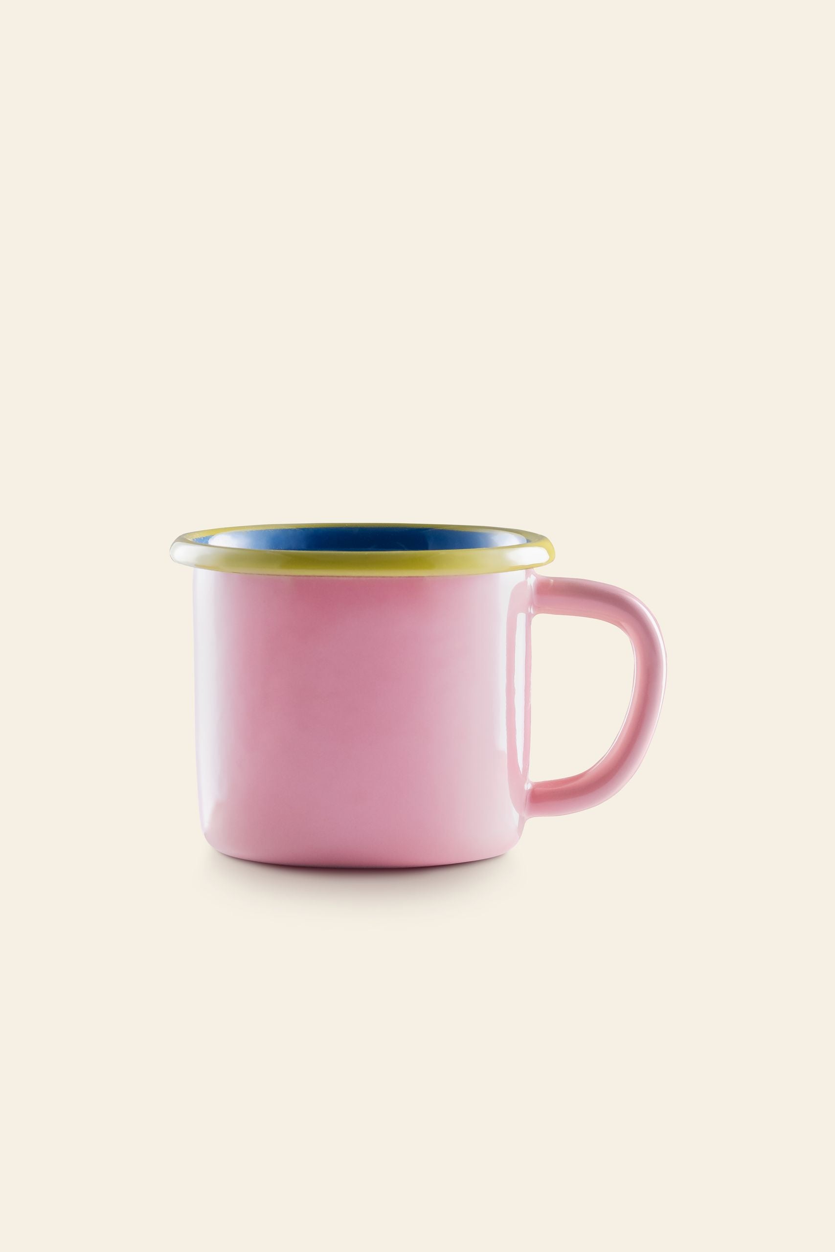 The Bornn Enamelware Colorama Mug by Bornn Enamelware features a pink exterior, yellow-rimmed edge, blue interior, and sturdy handle, set against a light beige background—an ideal charming addition to your mug collection.