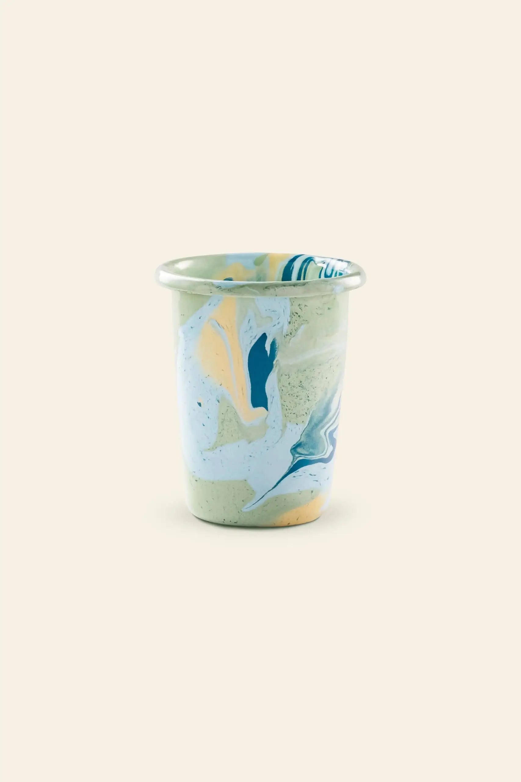 A small Bornn Enamelware New Marble Tumbler Cup, featuring a blue, yellow, and white marbled pattern on a plain beige background.