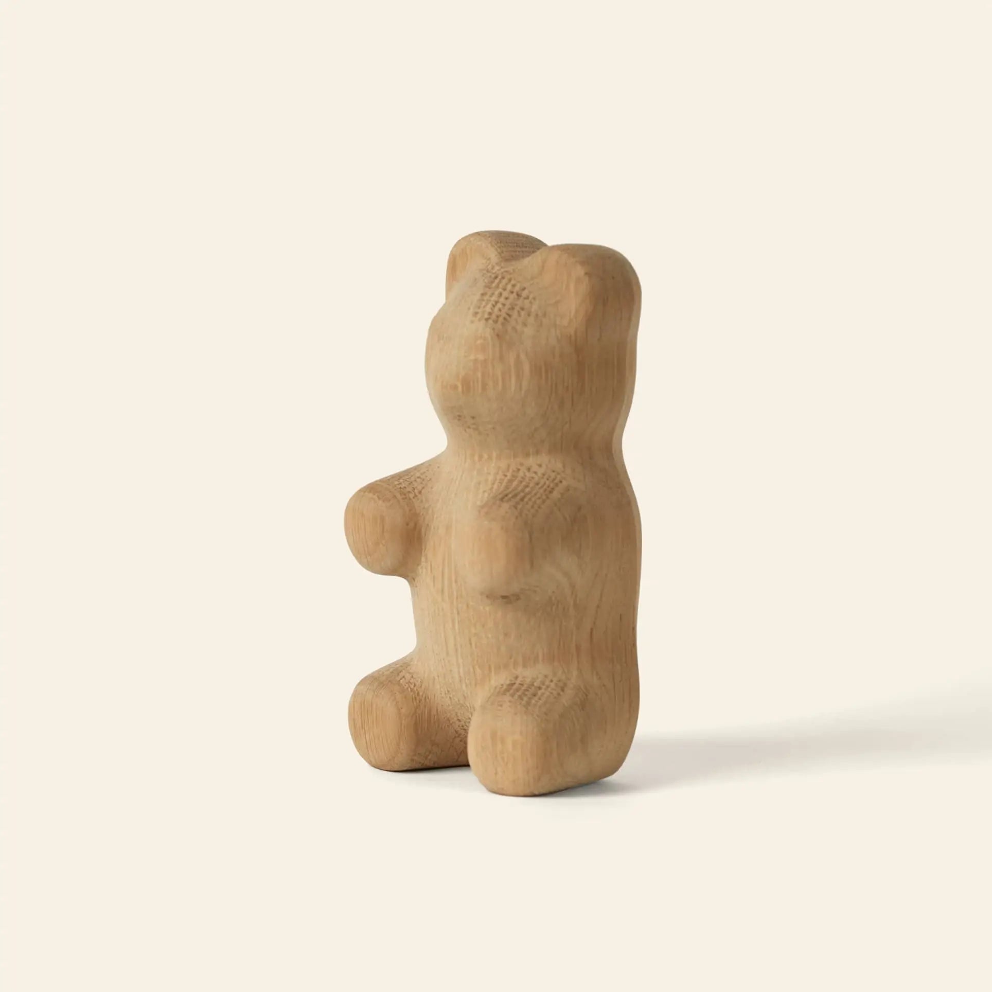 The Boyhood Gummy Bear Small by Boyhood is a smooth, light wooden figure shaped like a sitting bear, inspired by the classic candy and perfect for minimalist decor, shown against an off-white background.