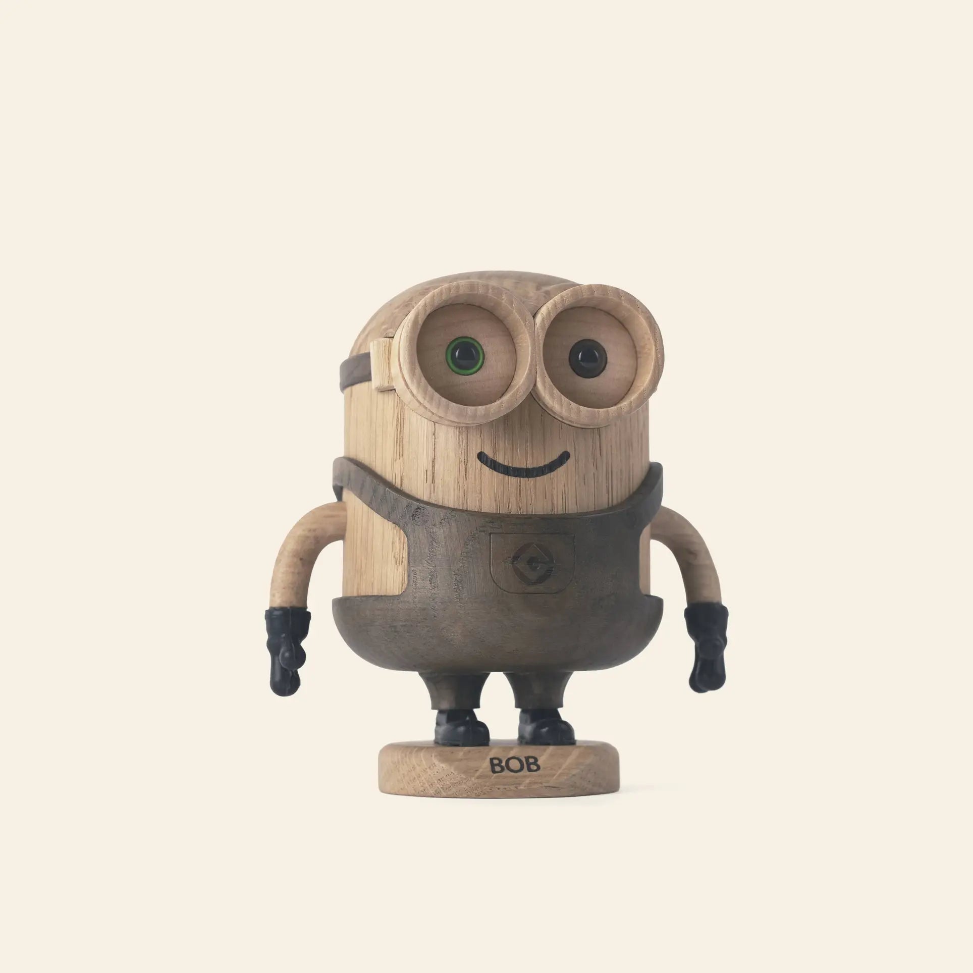 The Boyhood Minion Bob Small by Boyhood is a playful wooden figurine with goggles, a smiling face, black gloves and shoes, standing upright on a labeled BOB base against a plain light background.