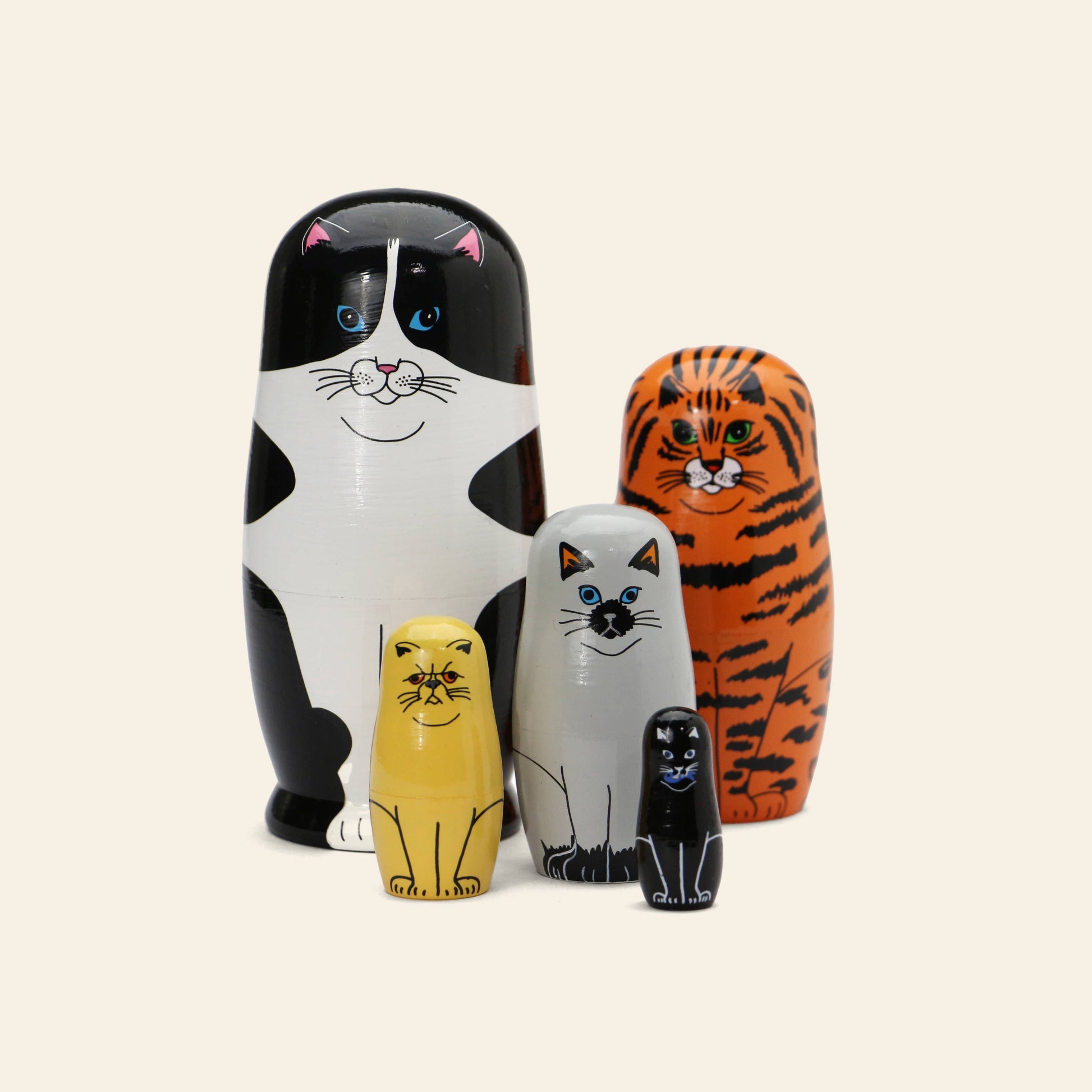 The DETAIL Feline 5 Nesting Dolls by DETAIL feature five wooden cat-themed nesting dolls, each with unique colors and patterns—an adorable set for cat lovers and collectors.