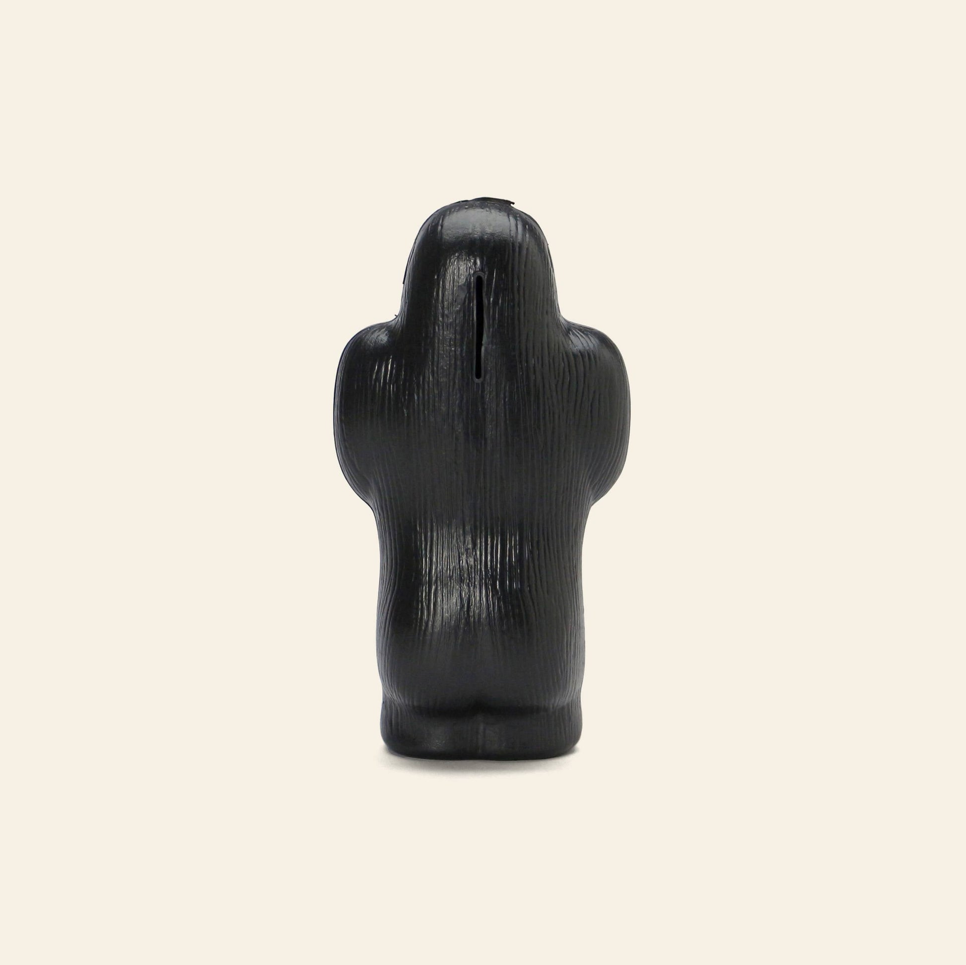 The DETAIL Gorilla Bank Small by DETAIL is a black, textured decorative bank shaped like a gorilla standing upright and facing away, shown against a plain beige background.