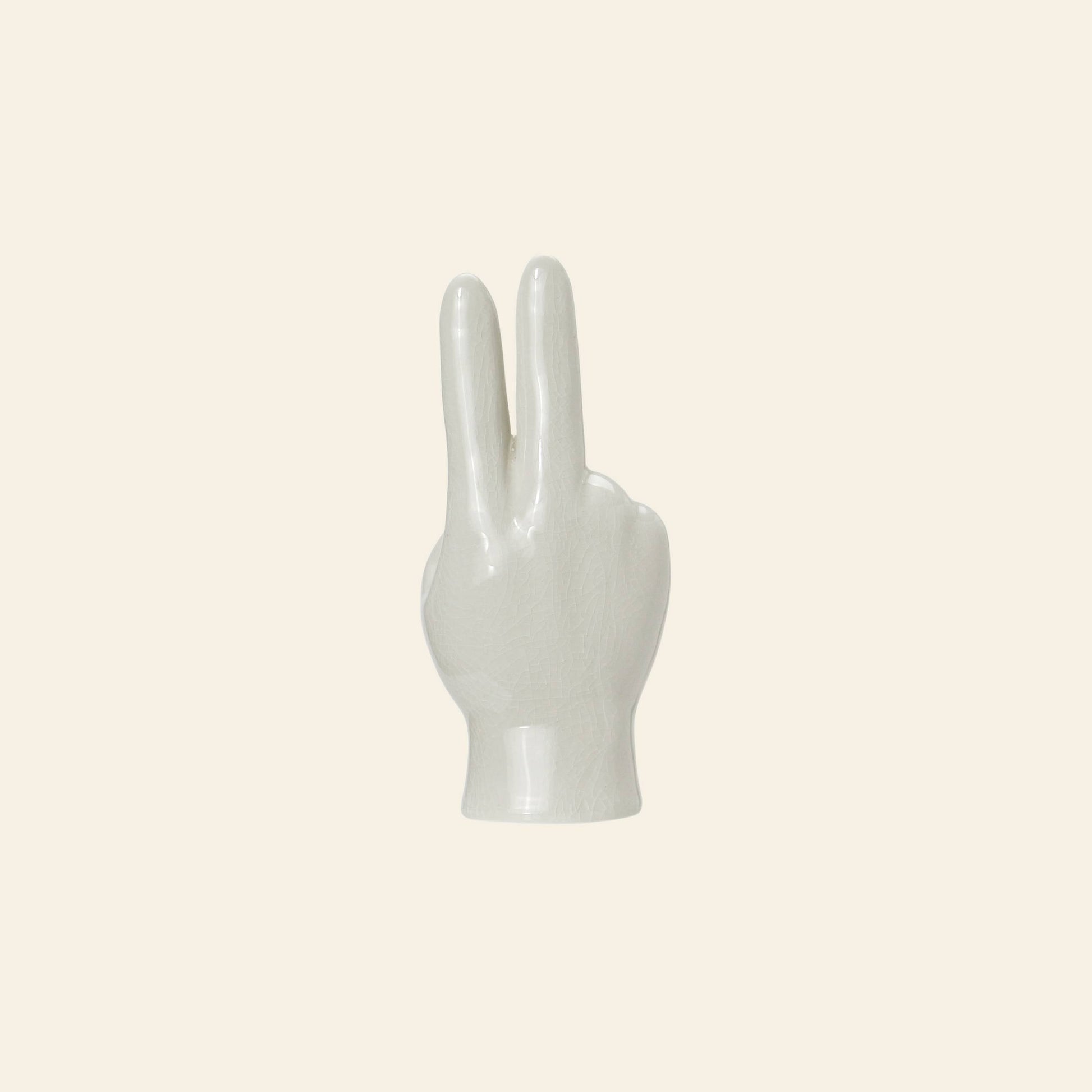 The DETAIL Porcelain Hand Peace by DETAIL is a white ceramic sculpture making a peace sign, ideal as a distinctive accessory stand or decorative object, shown against a plain light beige background.