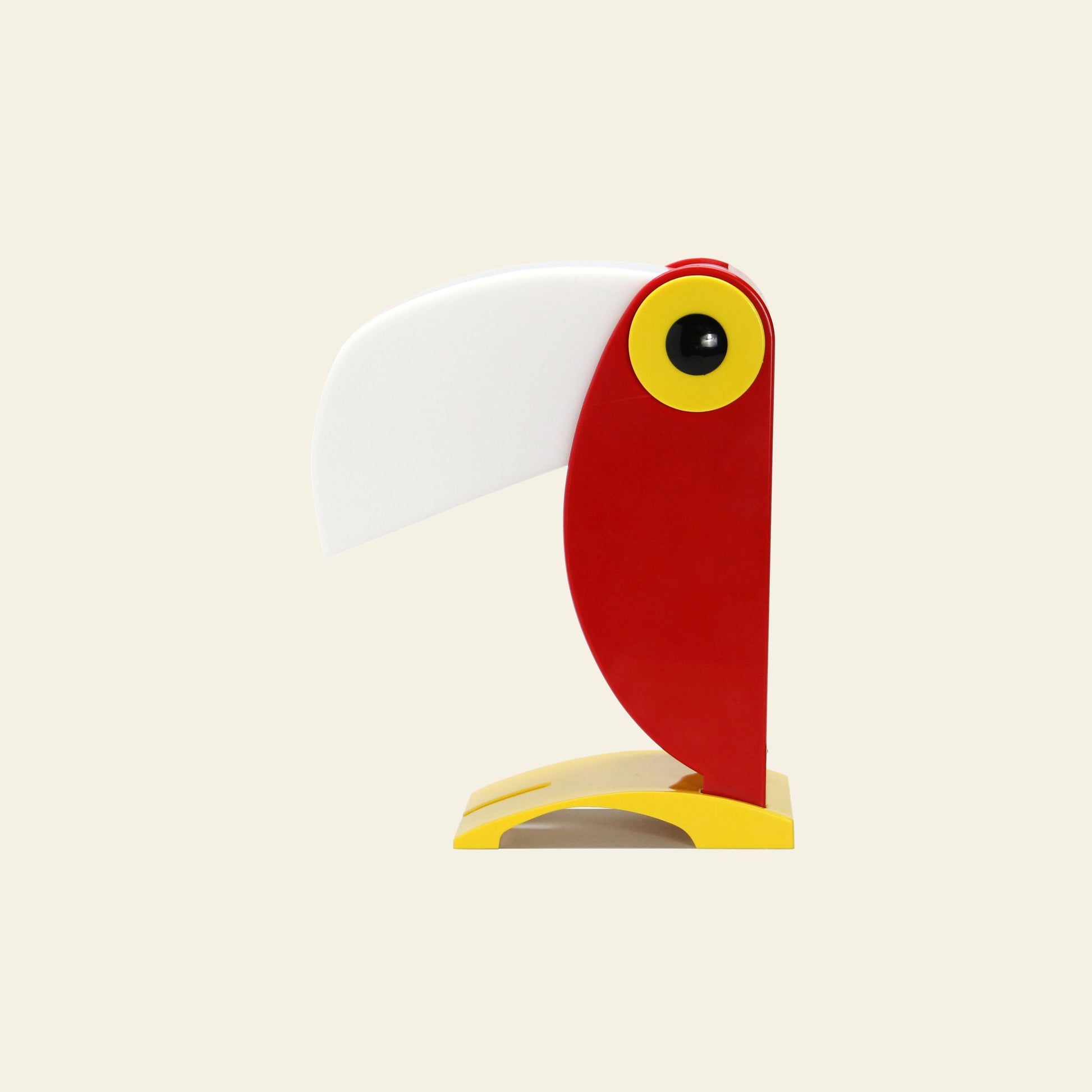 The DETAIL Toucan Lamp by DETAIL features an iconic design with a red body, yellow eye and base, and a large white beak on a beige background—ideal for adding vintage charm to any space.