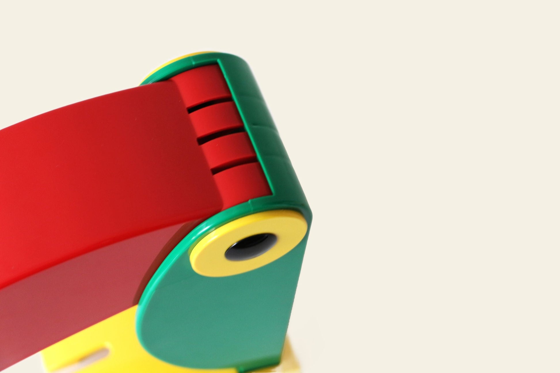 Close-up of the DETAIL Toucan Lamp by DETAIL, featuring vibrant red, yellow, and green parts that capture its iconic vintage design against a plain off-white background.