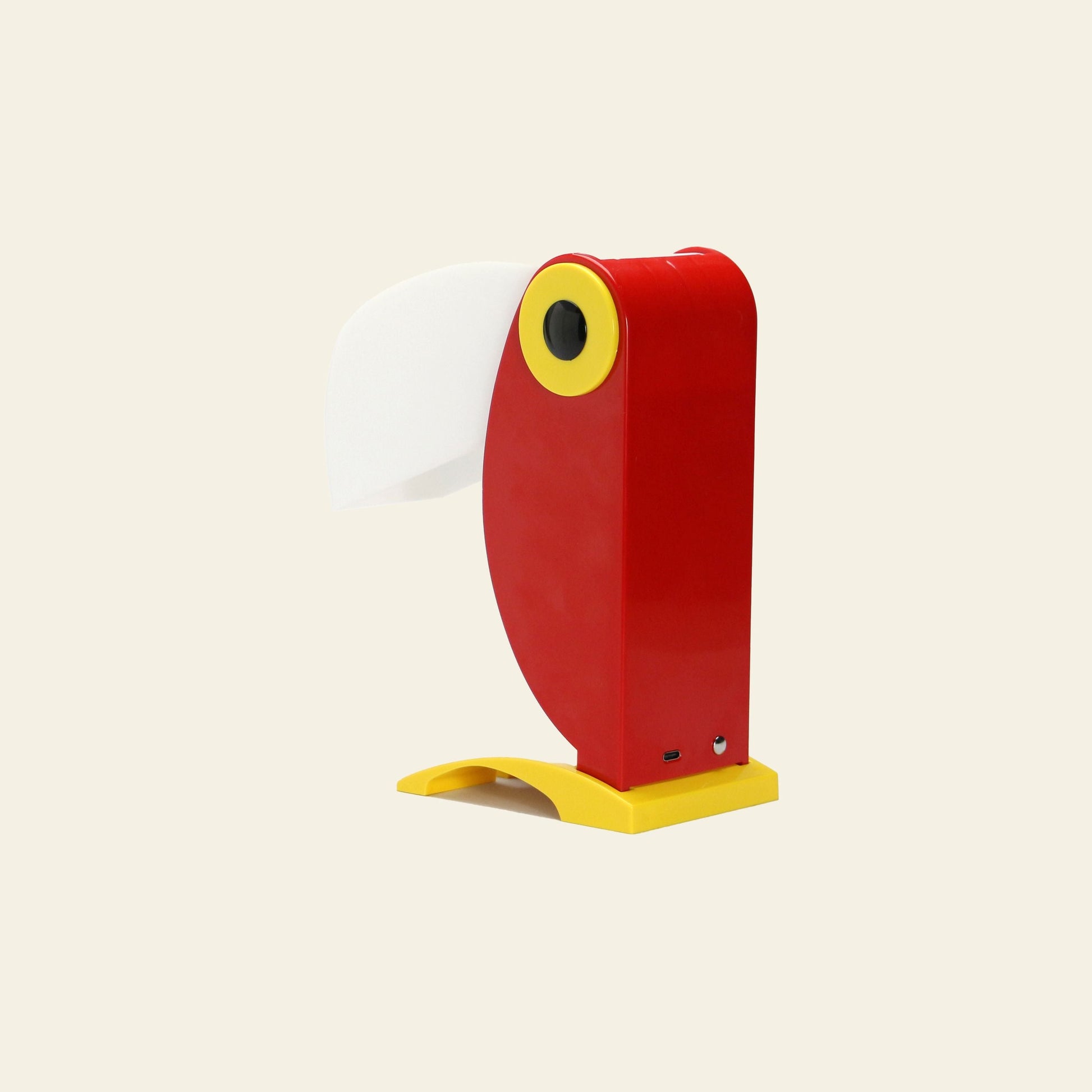 The DETAIL Toucan Lamp by DETAIL stands upright on a neutral background, featuring a playful red and yellow parrot-inspired design with a white beak that exudes vintage charm.