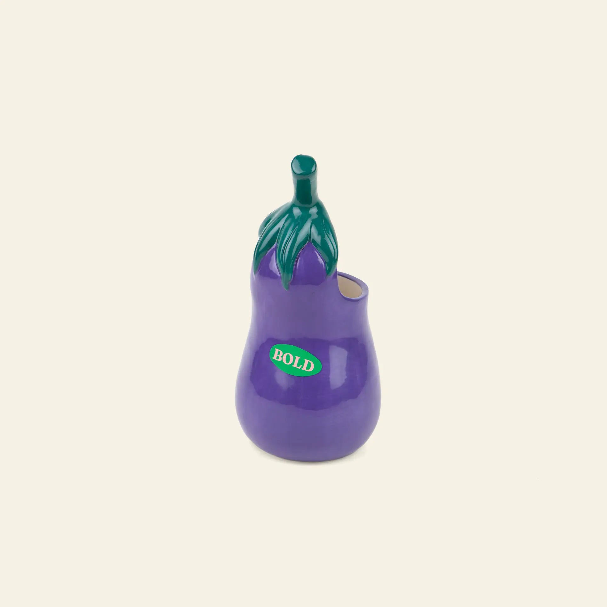 The DOIY Farmers’ Market Eggplant Utensils Pot by DOIY is a ceramic vase shaped like a purple eggplant with green stem and leaves—ideal as an utensil holder or quirky vegetable-themed kitchen decor.