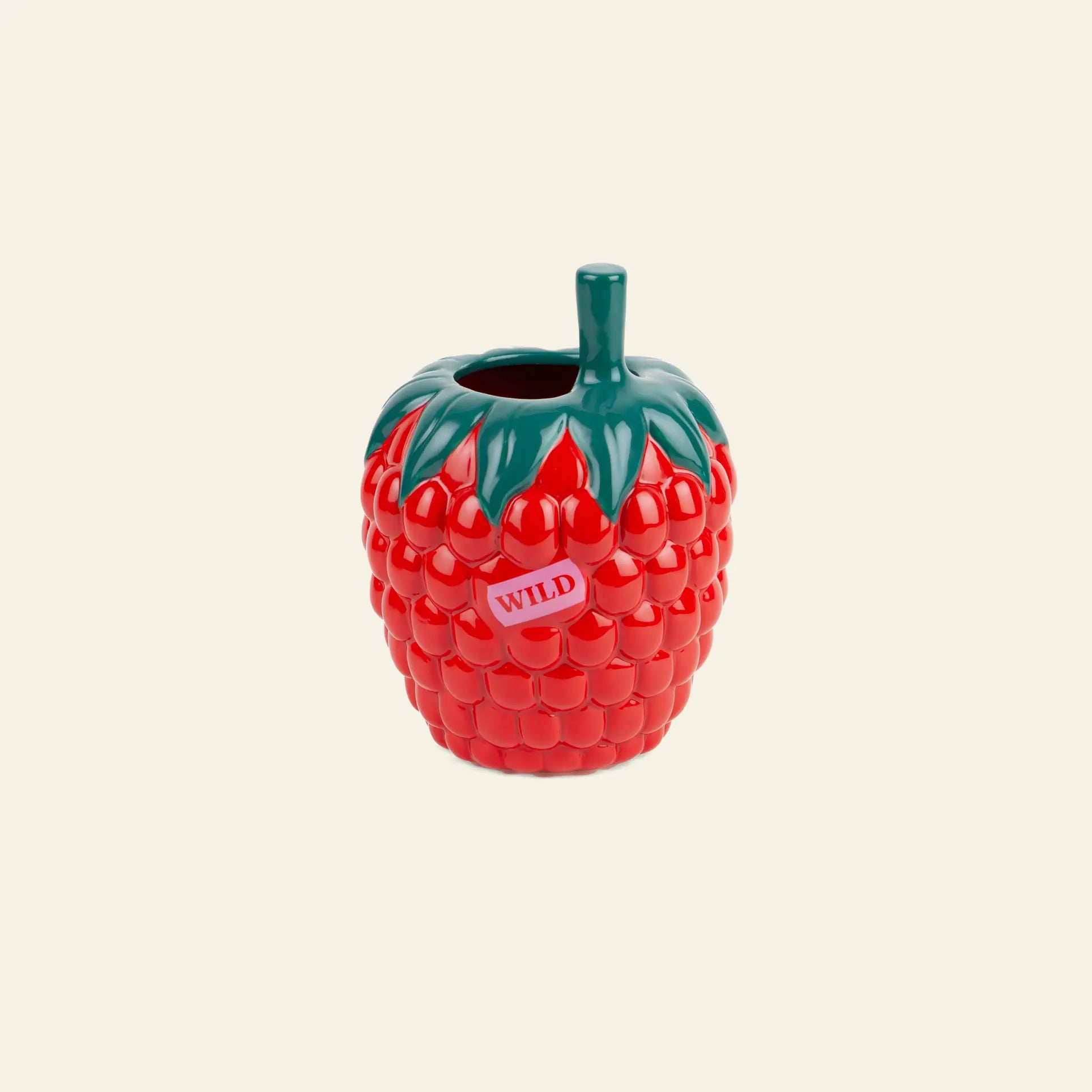 The DOIY Farmers Market Raspberry Vase by DOIY features a playful, bright red raspberry shape with green leaves, a short stem, and a “WILD” sticker—perfect for adding vibrant charm to your home decor against a light beige background.
